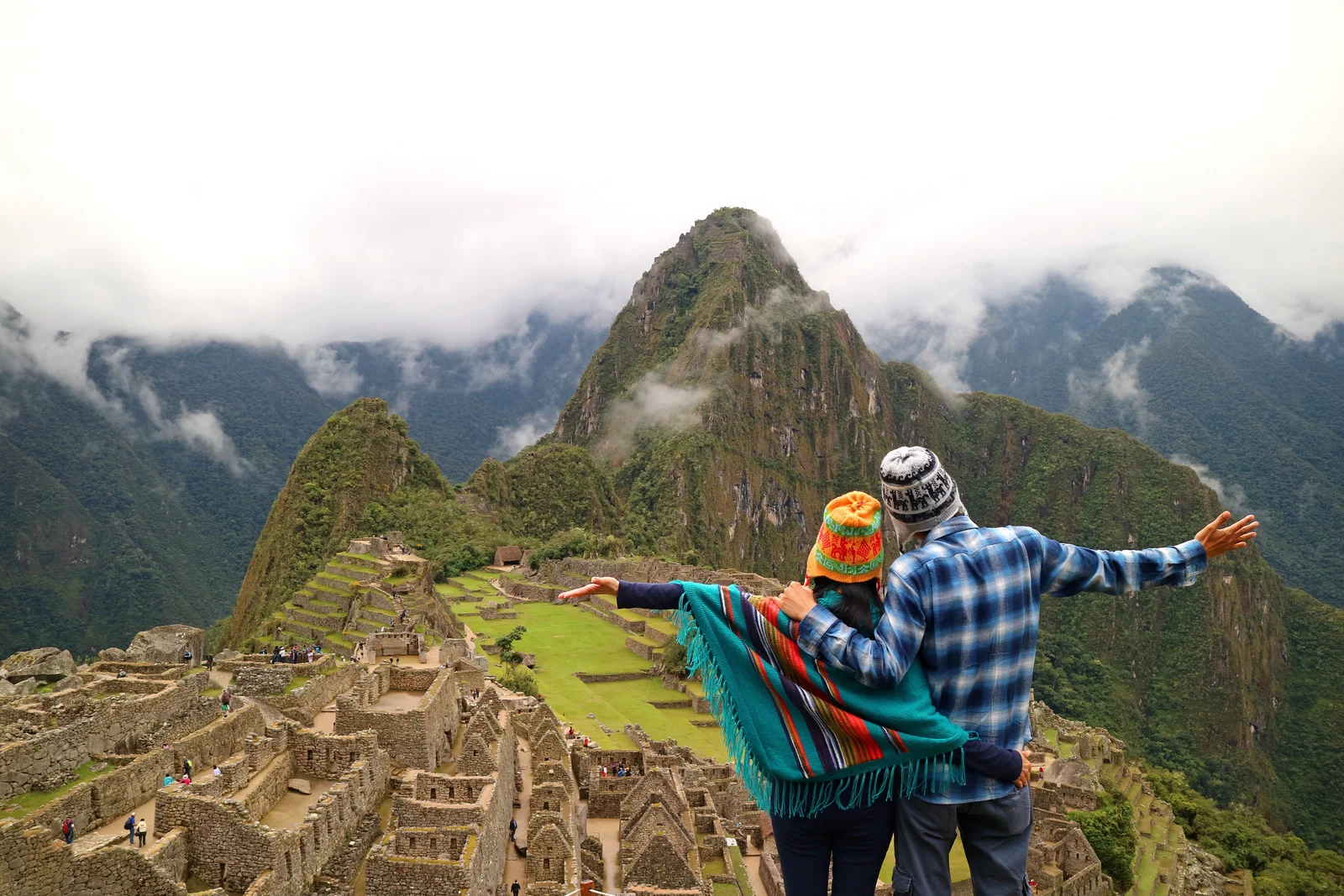 Tourists overlooking Machu Picchu ruins in the Andes mountains of Peru on a clear September day.