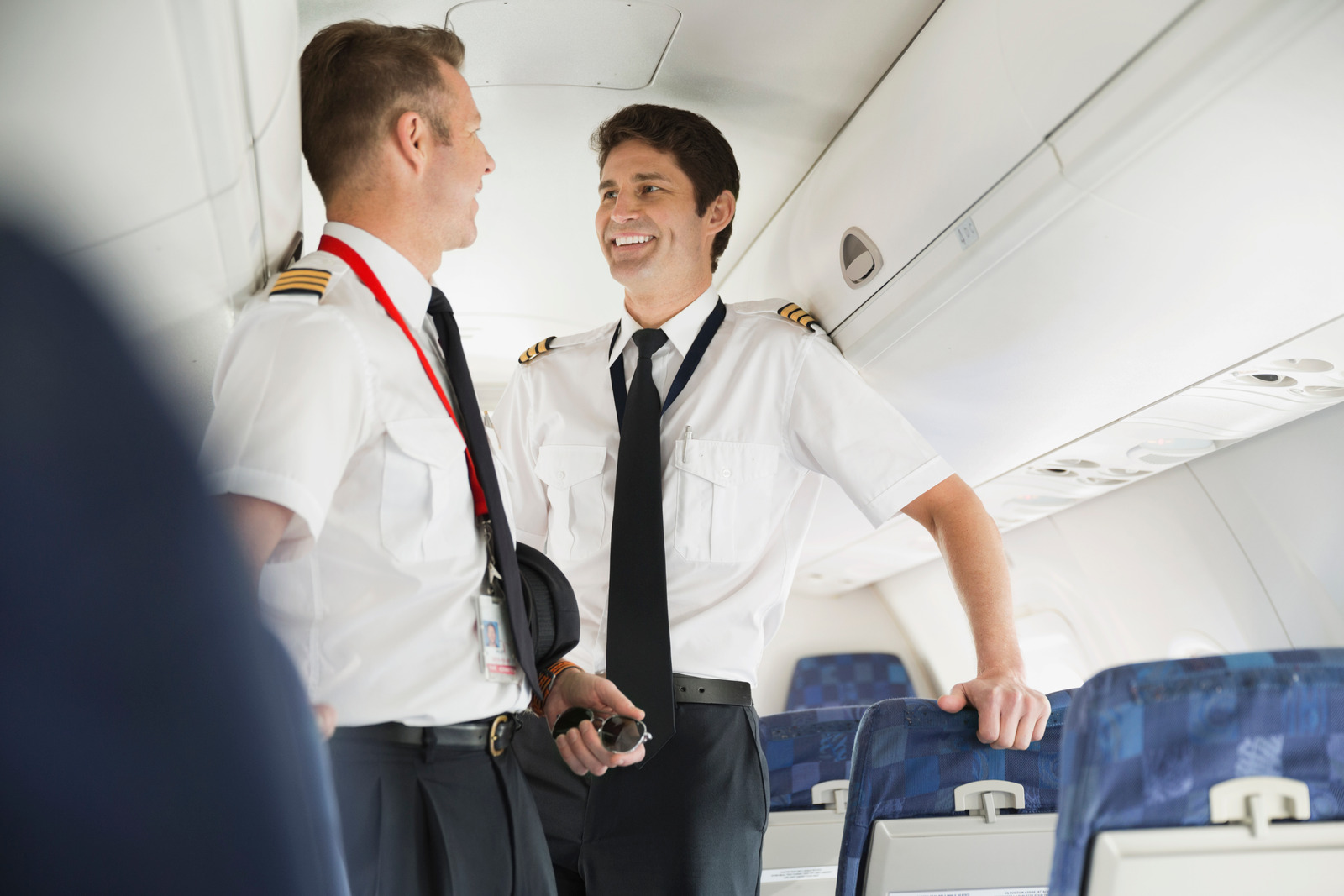 Airline pilots smiling after landing, reminder that thanking only pilots is bad airplane etiquette flight attendants dislike.