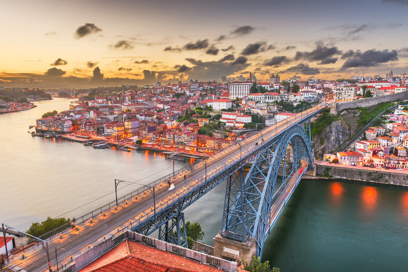 Aerial view of Porto, Portugal at sunset with the Dom Luís I Bridge spanning the Douro River.