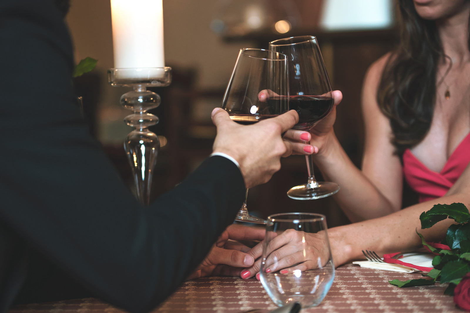 Romantic couple clinking wine glasses at an Italian restaurant during a date.