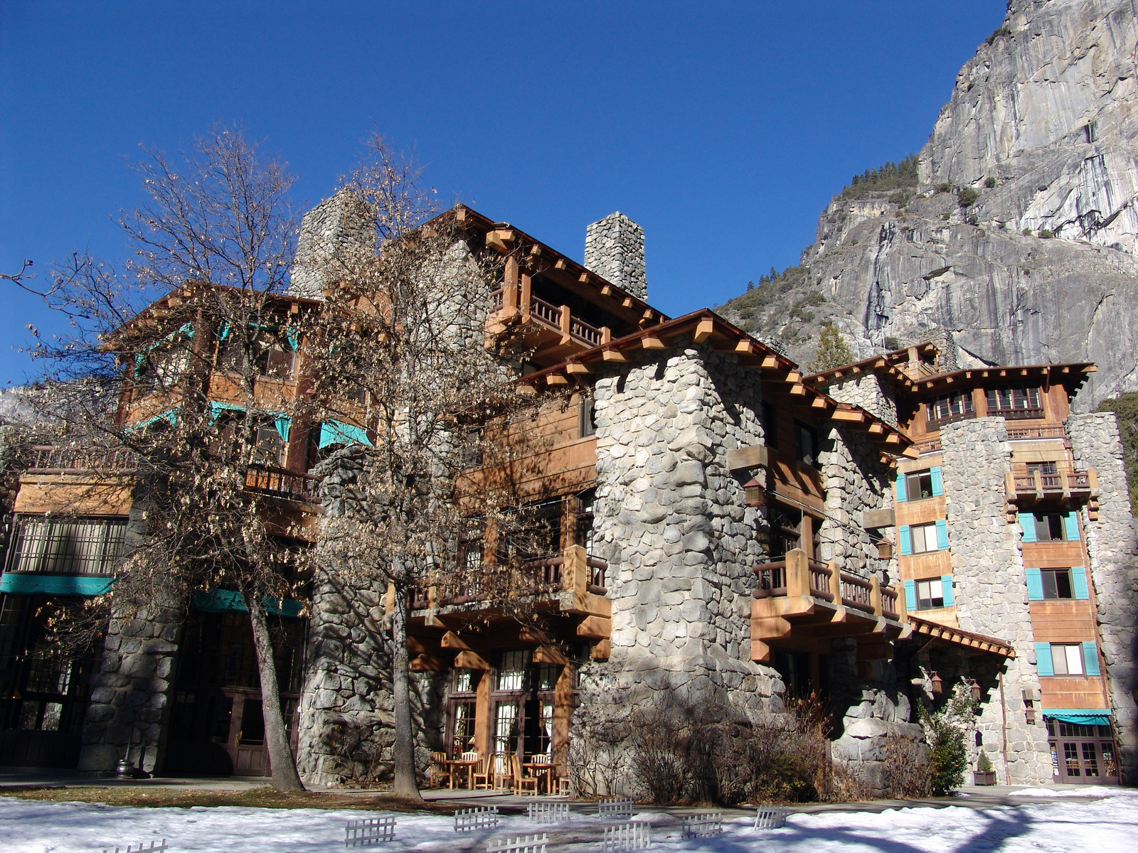The historic Ahwahnee Hotel in Yosemite National Park with stone architecture, wooden balconies, and granite cliffs in the background