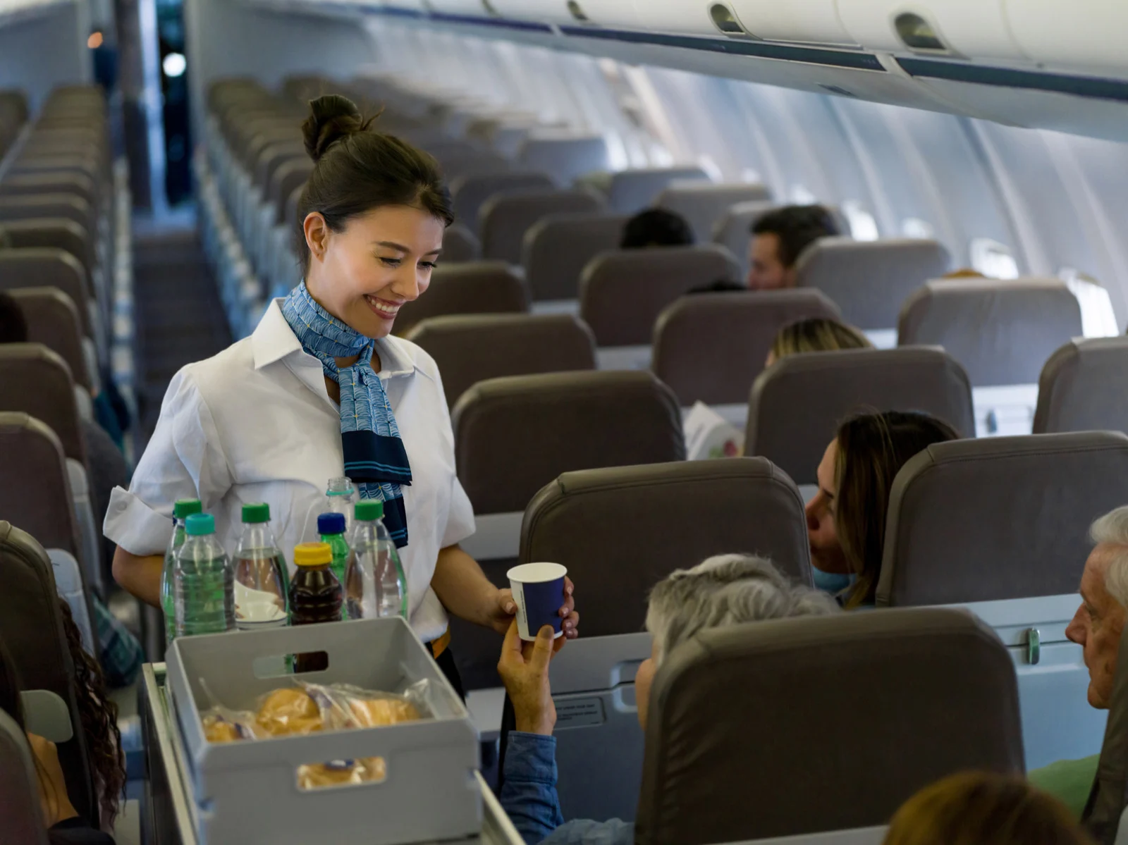 Passenger rearranging bags in airplane overhead bin, an example of bad airplane etiquette and polite habits flight attendants secretly hate.