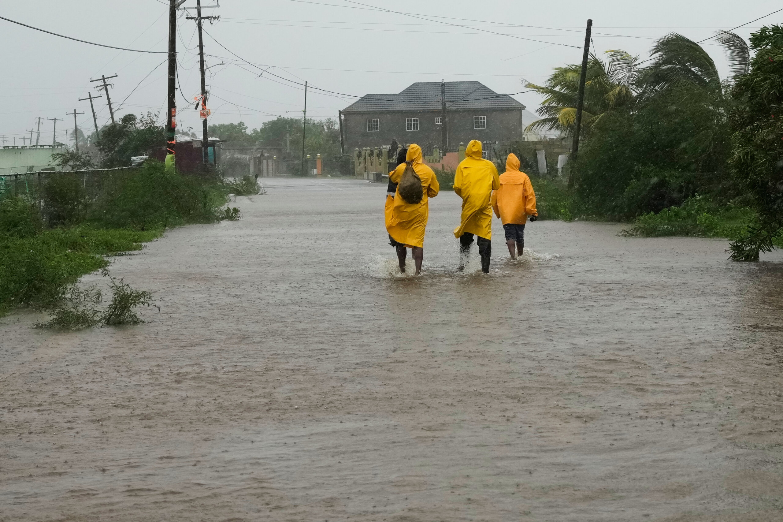 People walk along a road during the passing of Hurricane Melissa in Rocky Point, Jamaica, Tuesday, Oct. 28, 2025.