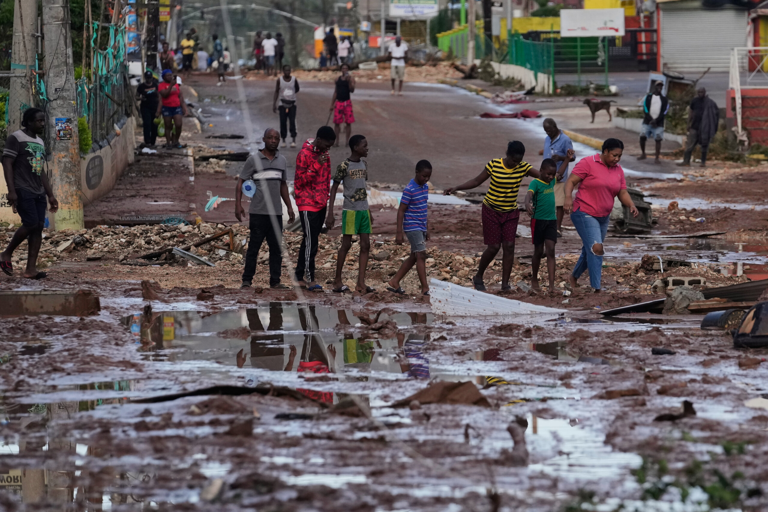 People walk through Santa Cruz, Jamaica, Wednesday, Oct. 29, 2025, after Hurricane Melissa passed.
