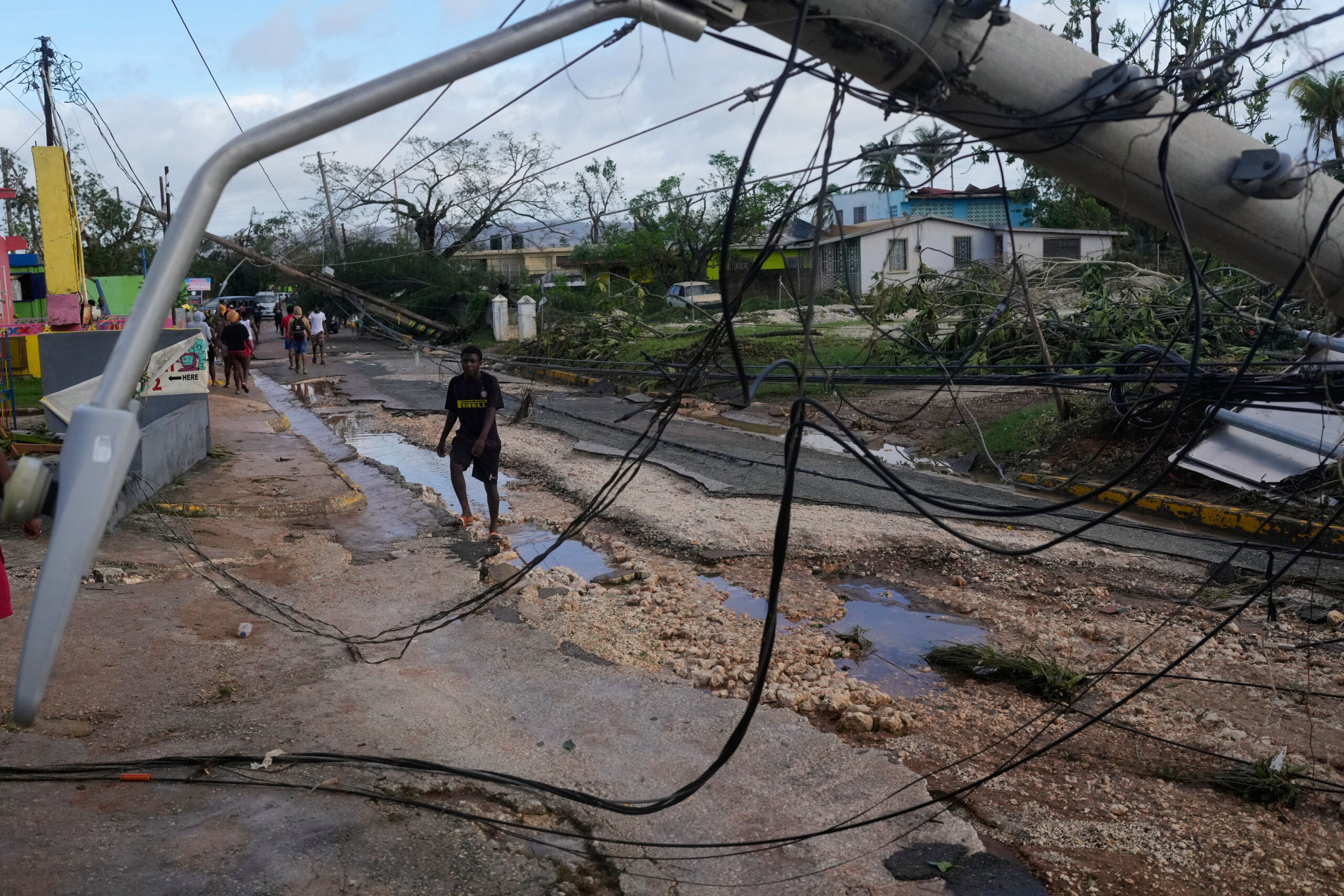 Residents walking through storm-damaged Santa Cruz, Jamaica, after Hurricane Melissa