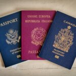 Three passports — U.S., Italian, and Canadian — lying side by side on a table
