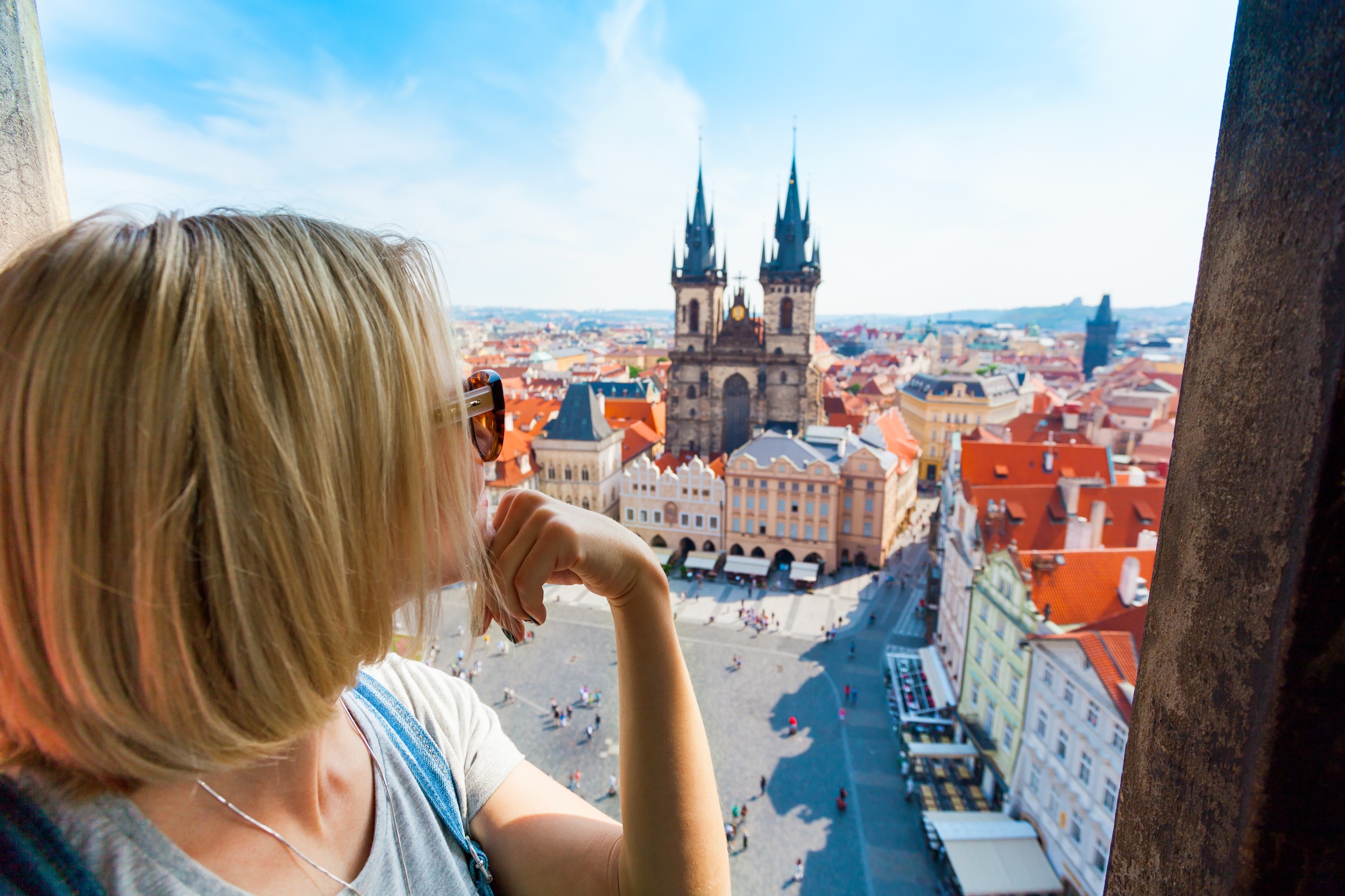 Kostel Panny Marie pred Tynem. Church of the Virgin Mary. A young woman stands on top of the clock tower and looks at the Old Town Square in Prague