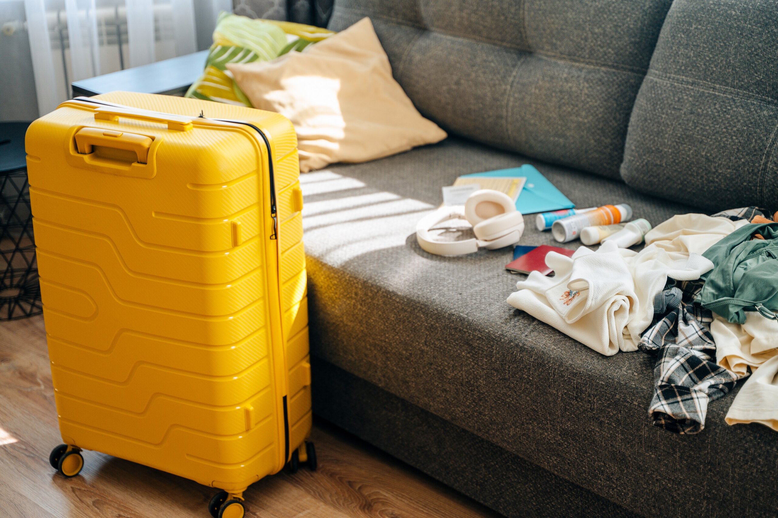 A suitcase packed with clothes, travel items and accessories representing preparation for a trip or vacation. Travel, organization and adventure planning concept