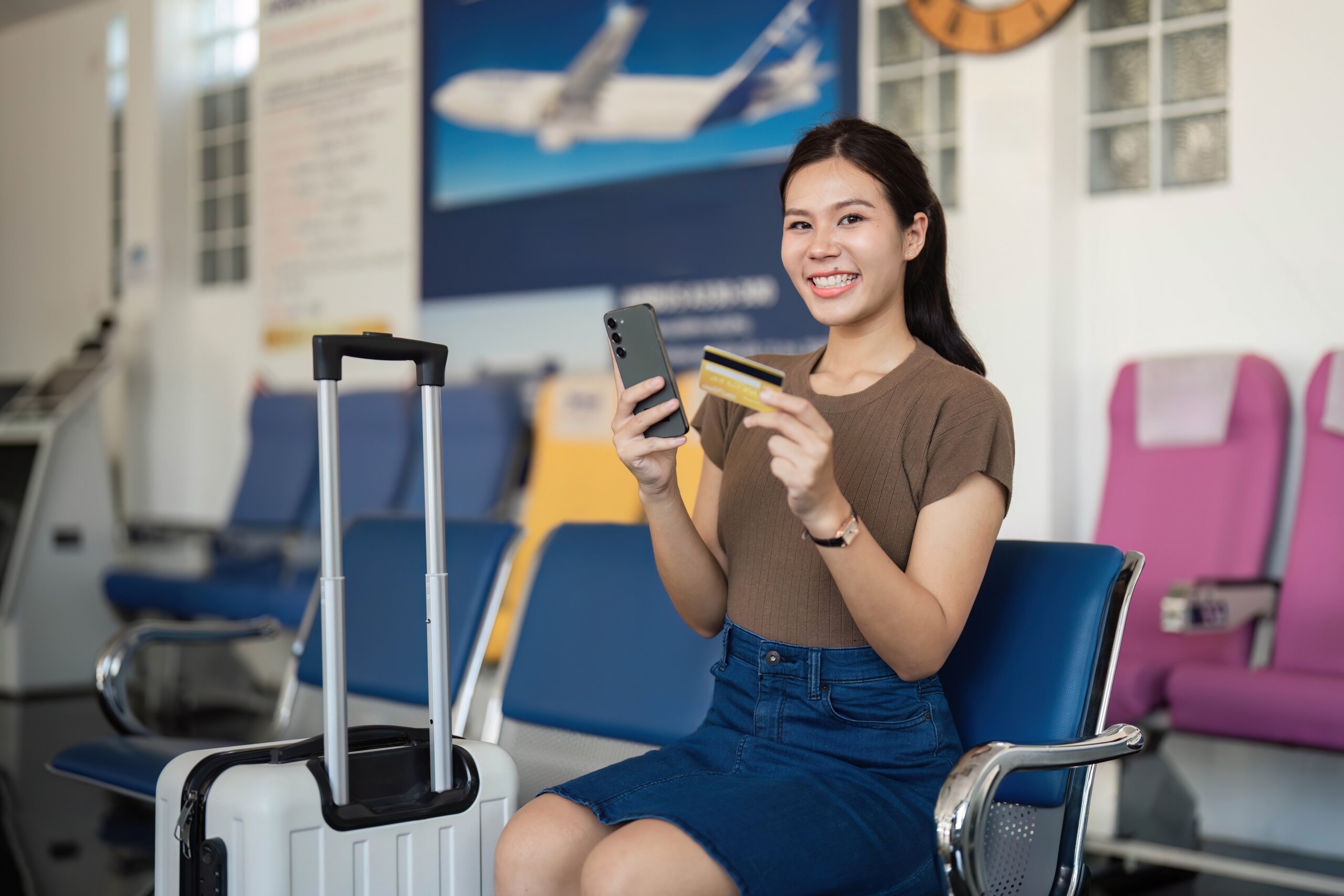 U.S. travel rules 2025: Travel excitement with a young woman showing credit card and phone