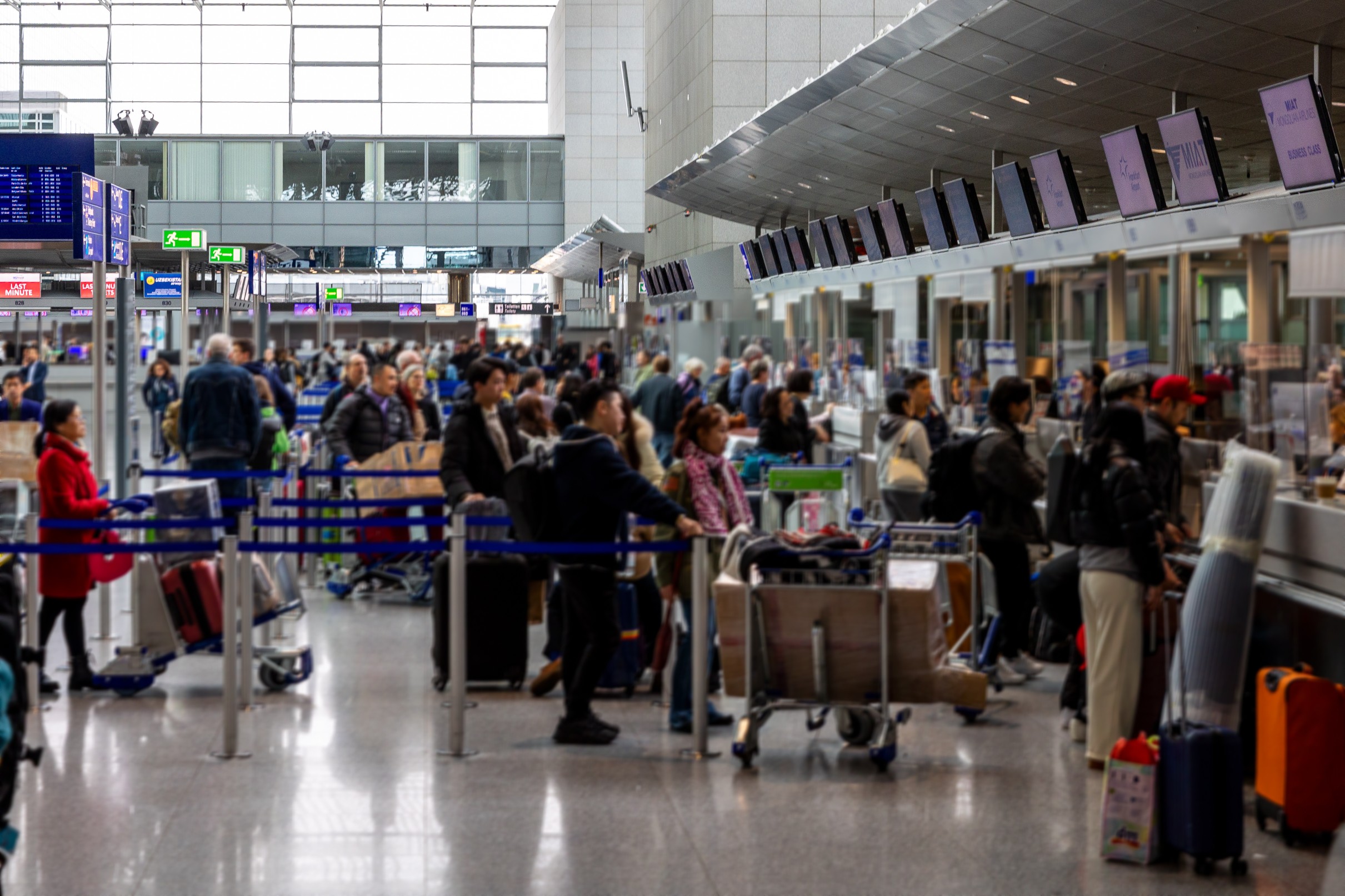 busy airport check-in counter with travelers and luggage