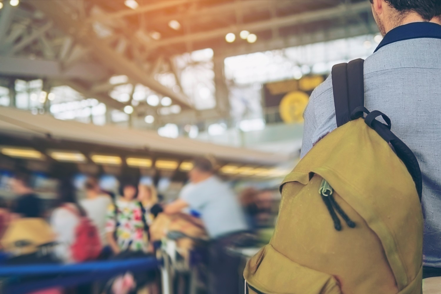 Soft focused picture of traveler over blurred long passenger queue waiting for check-in at airport check-in counters
