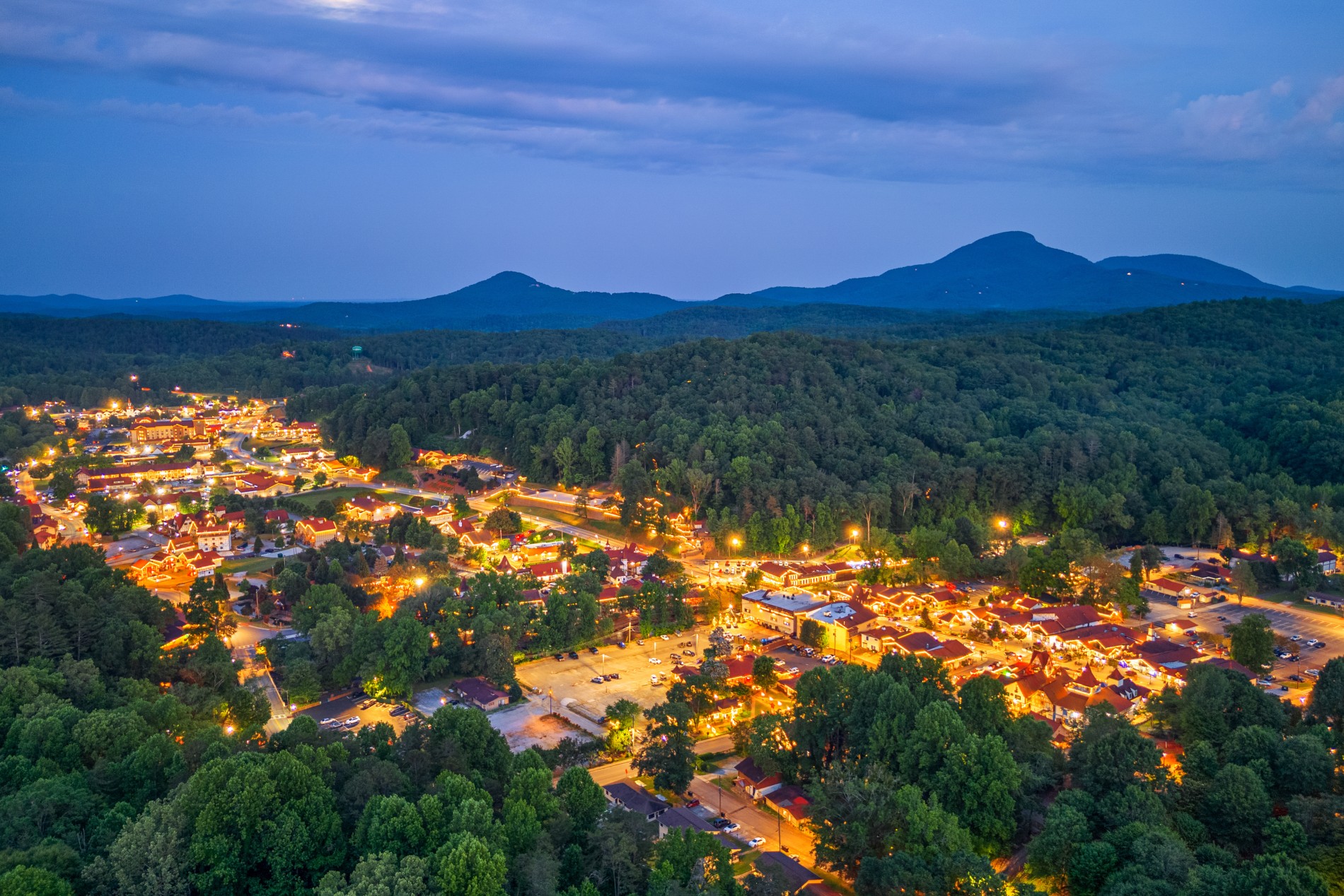 Aerial view of Helen, Georgia at night with lights glowing in the Blue Ridge Mountains.