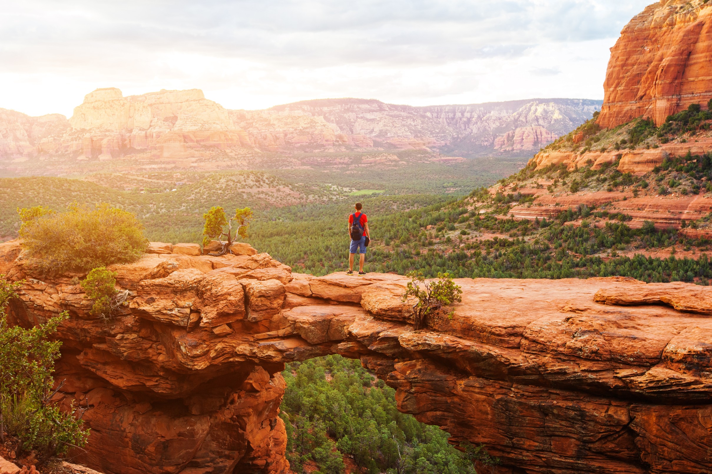 Travel in Devil's Bridge Trail, man Hiker with backpack enjoying view, Sedona, Arizona, USA

