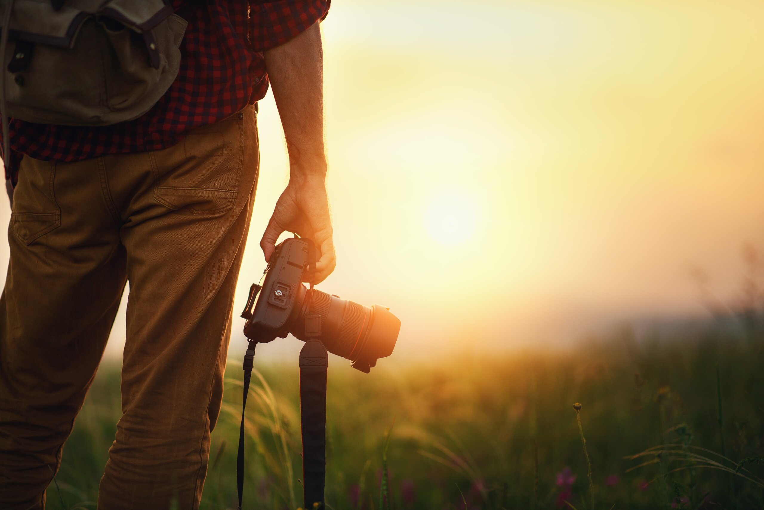 travel photographer. man traveler with camera at sunset in nature
