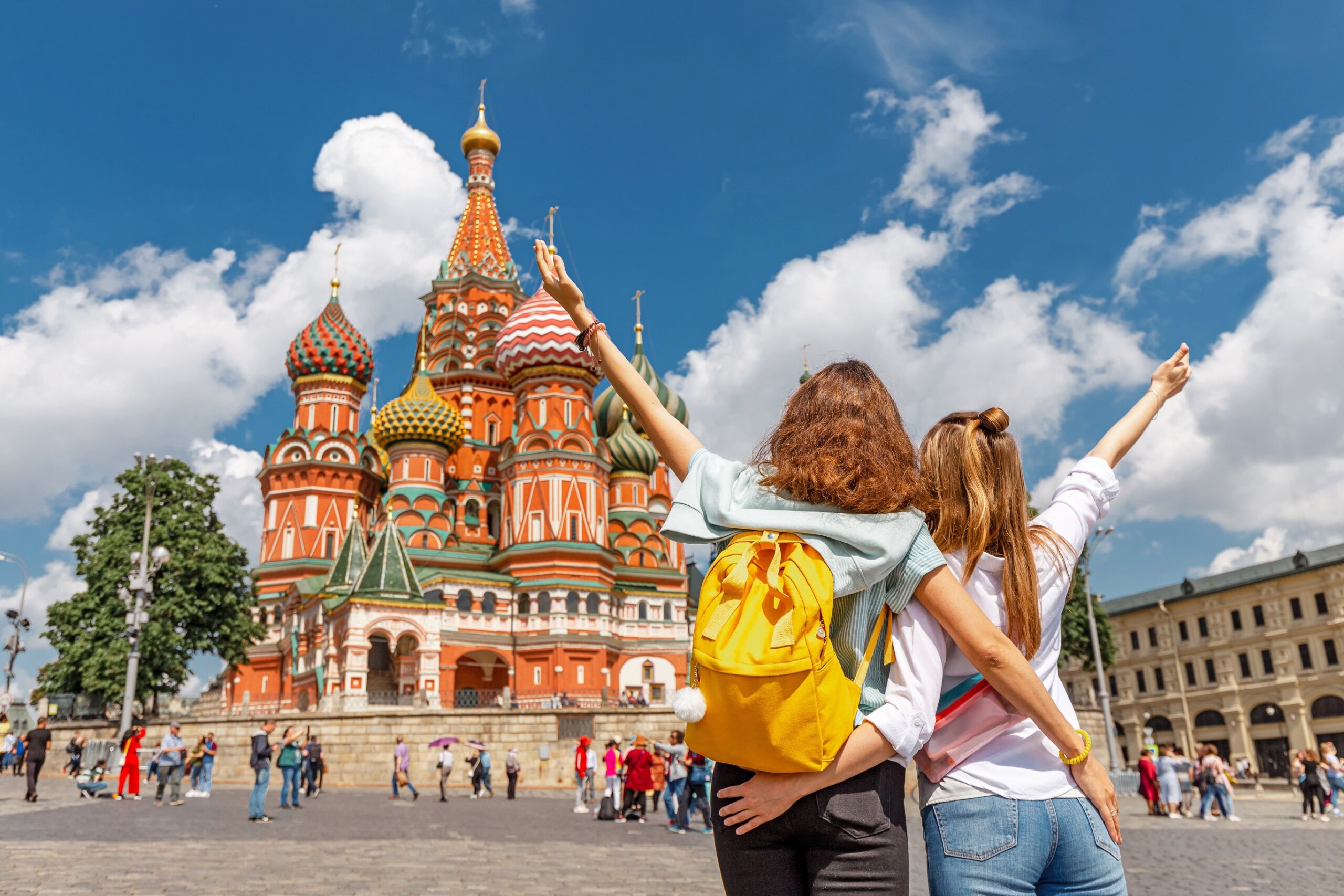 Two happy young happy girls travel in Russia and taking selfie in front of the St Basil Cathedral