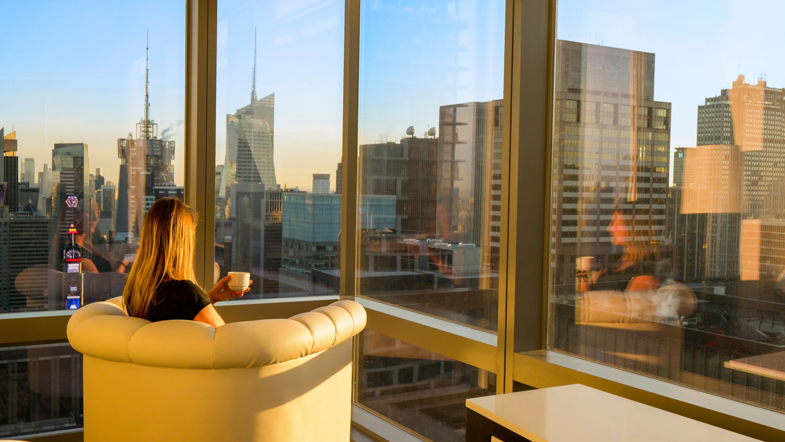 Girl enjoying the view of New York in morning with a cup of coffee.