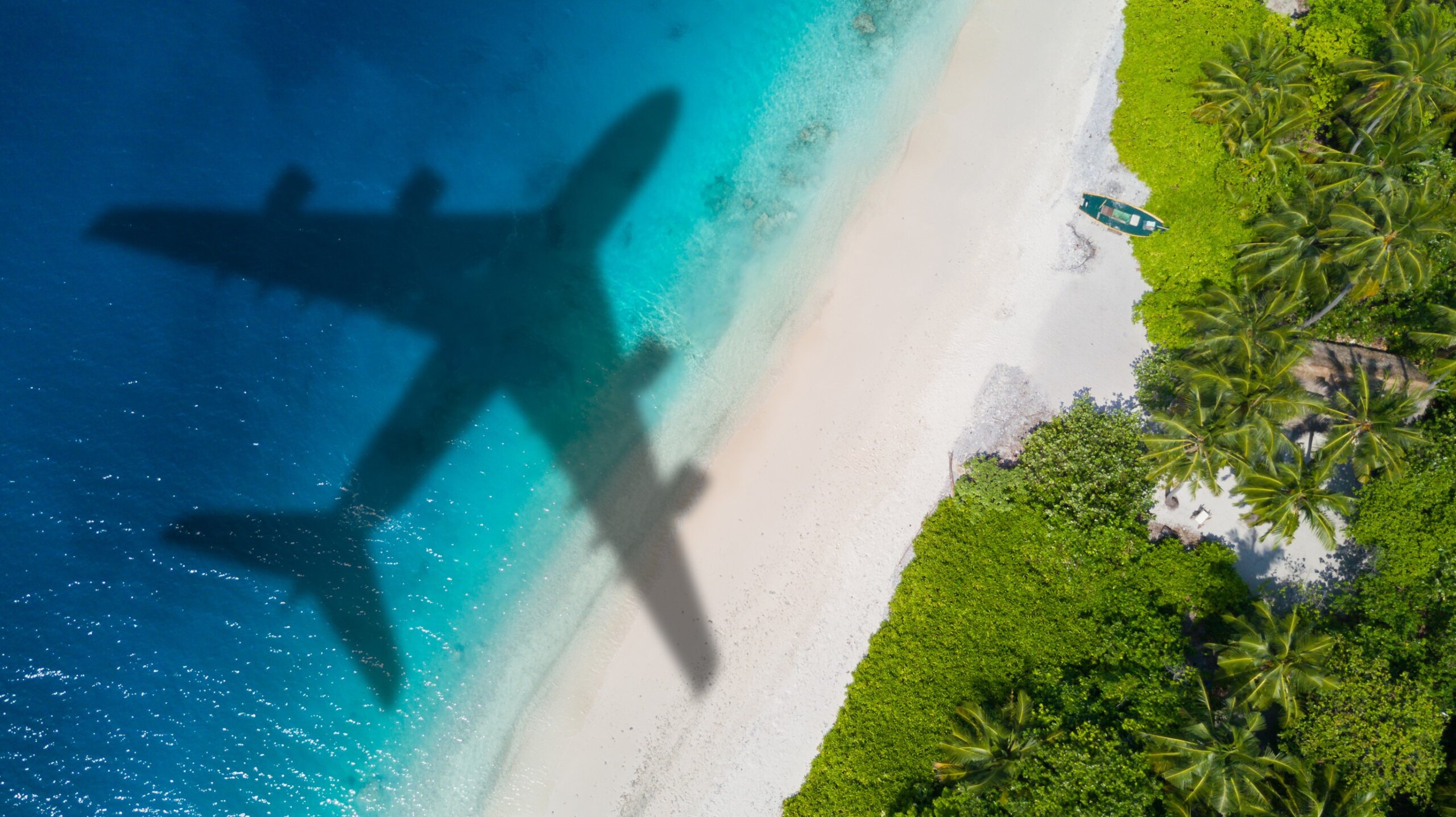 Airplane shadow over tropical beach representing 2025 U.S. travel rule changes