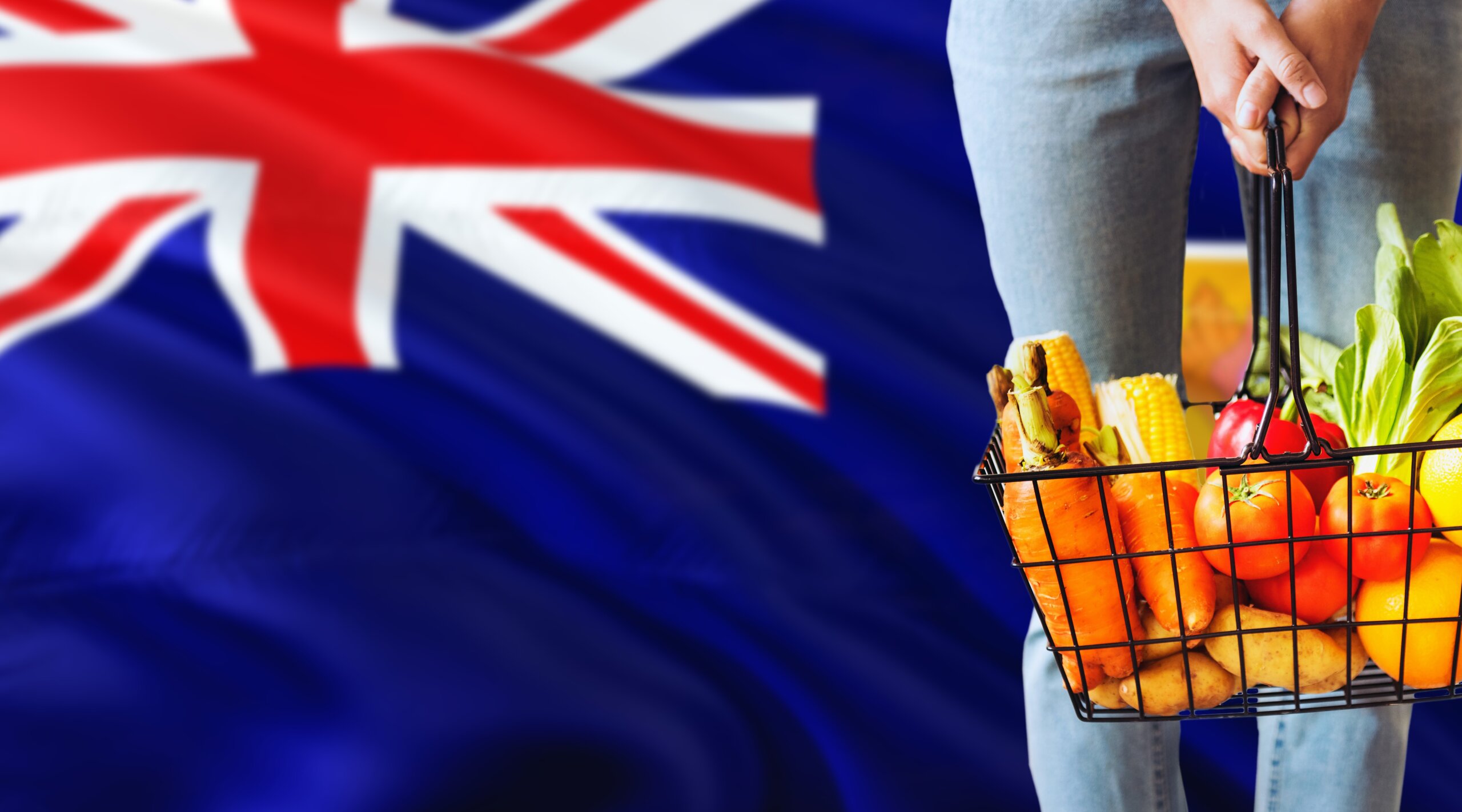 Woman is holding supermarket basket, Turks And Caicos Islands waving flag background. Economy concept for fresh fruits and vegetables.
