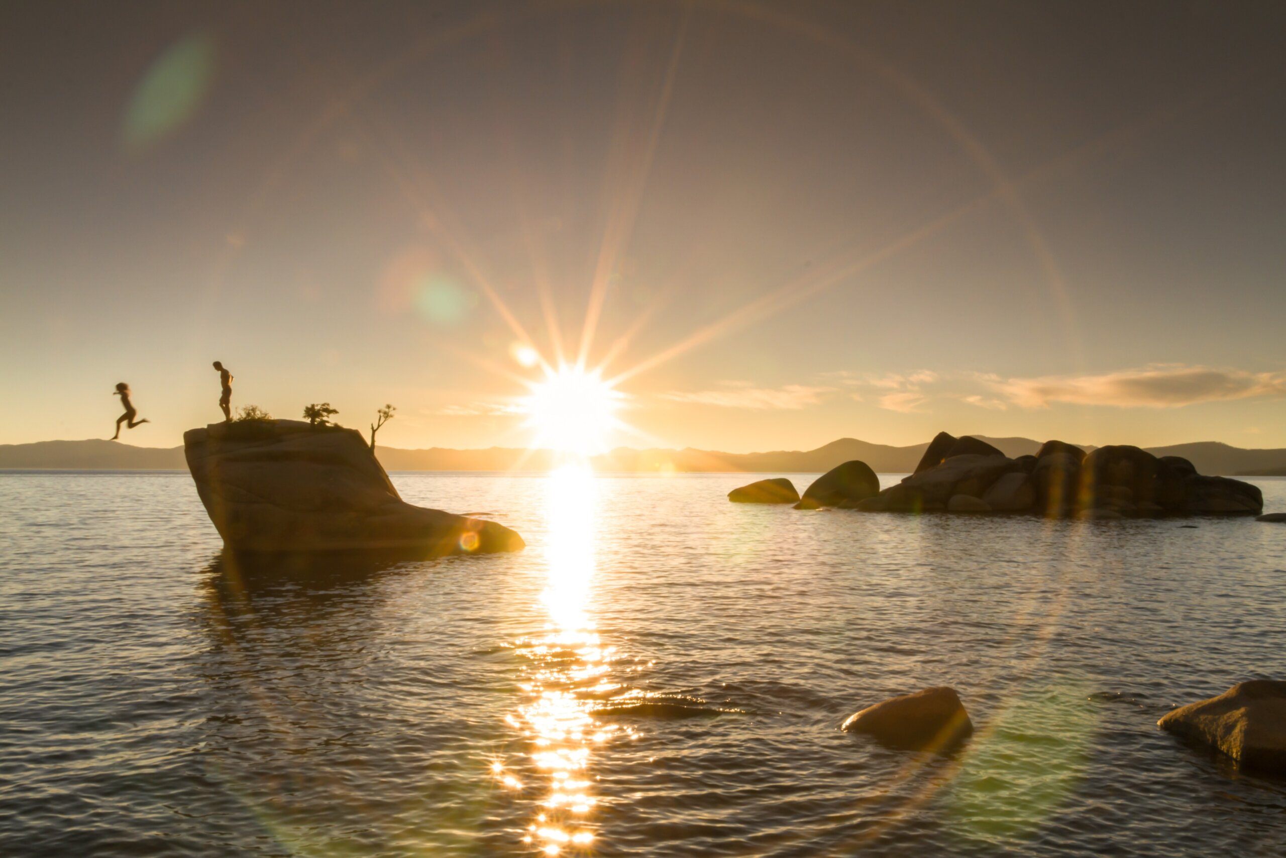 People jumping off Bonsai Rock in Lake Tahoe, California
