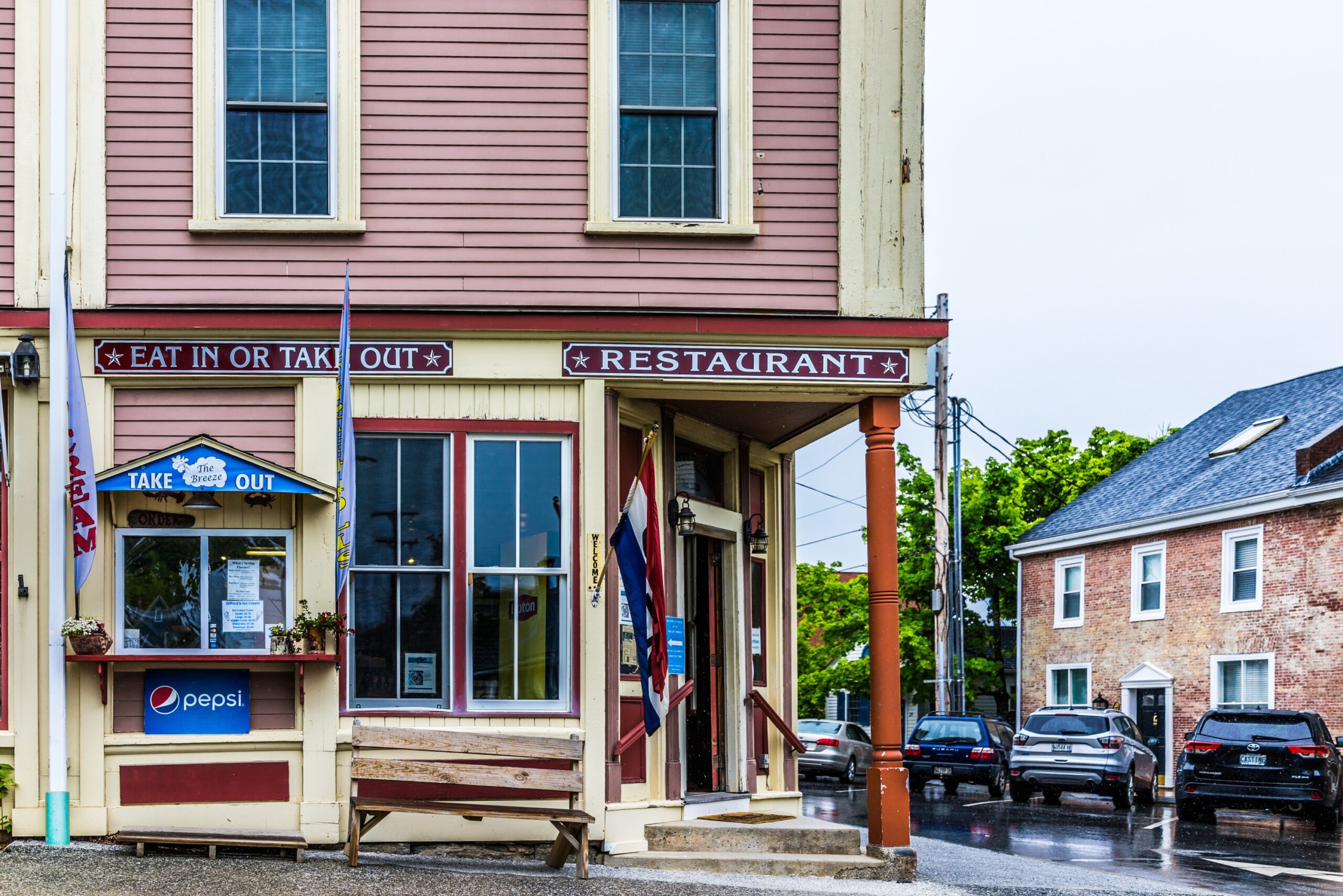 Castine, USA - June 9, 2017: Empty small village in Maine during rain with brick restaurant building and take out window