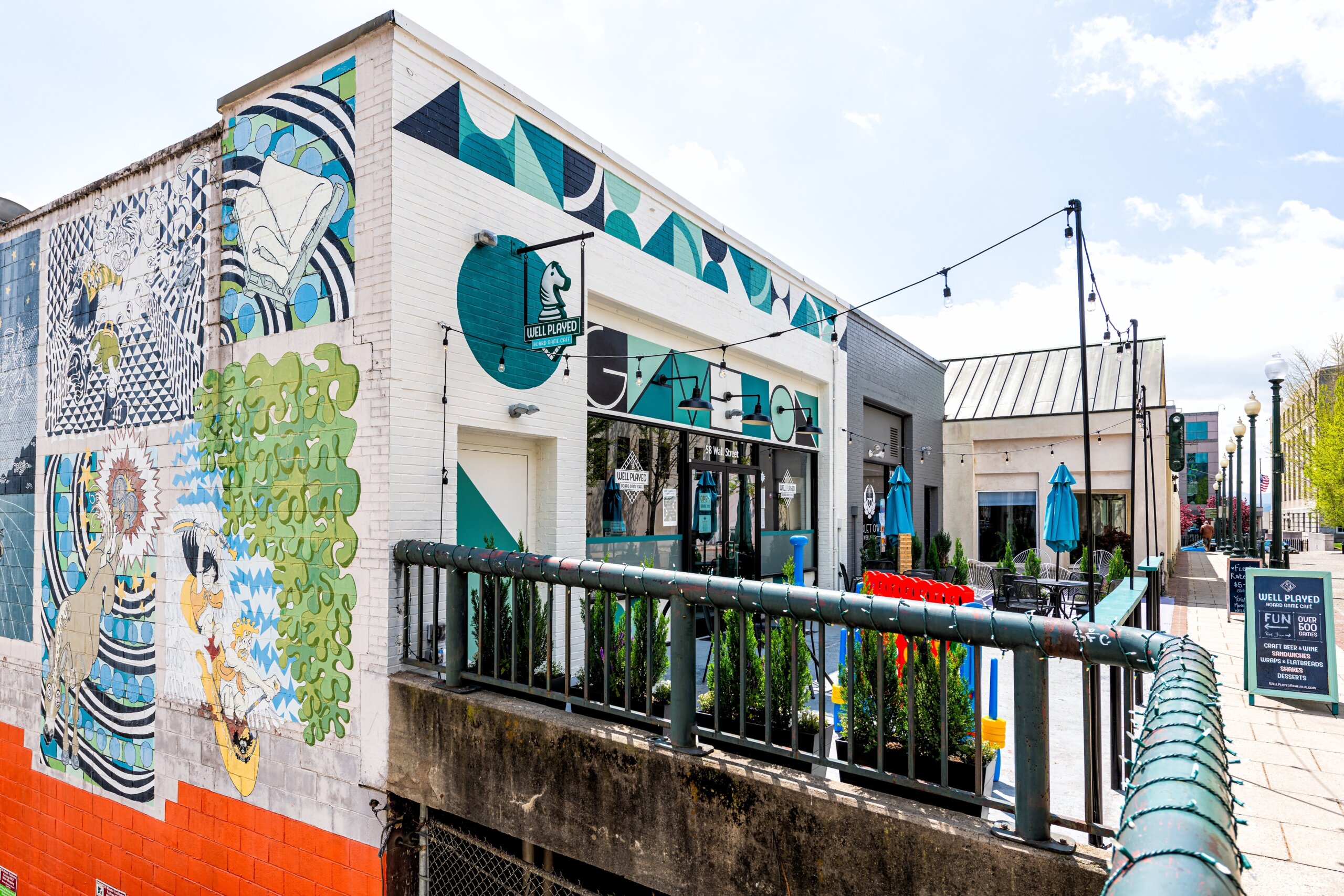 Well played board games cafe by Wall street sidewalk road with stores, shops restaurants