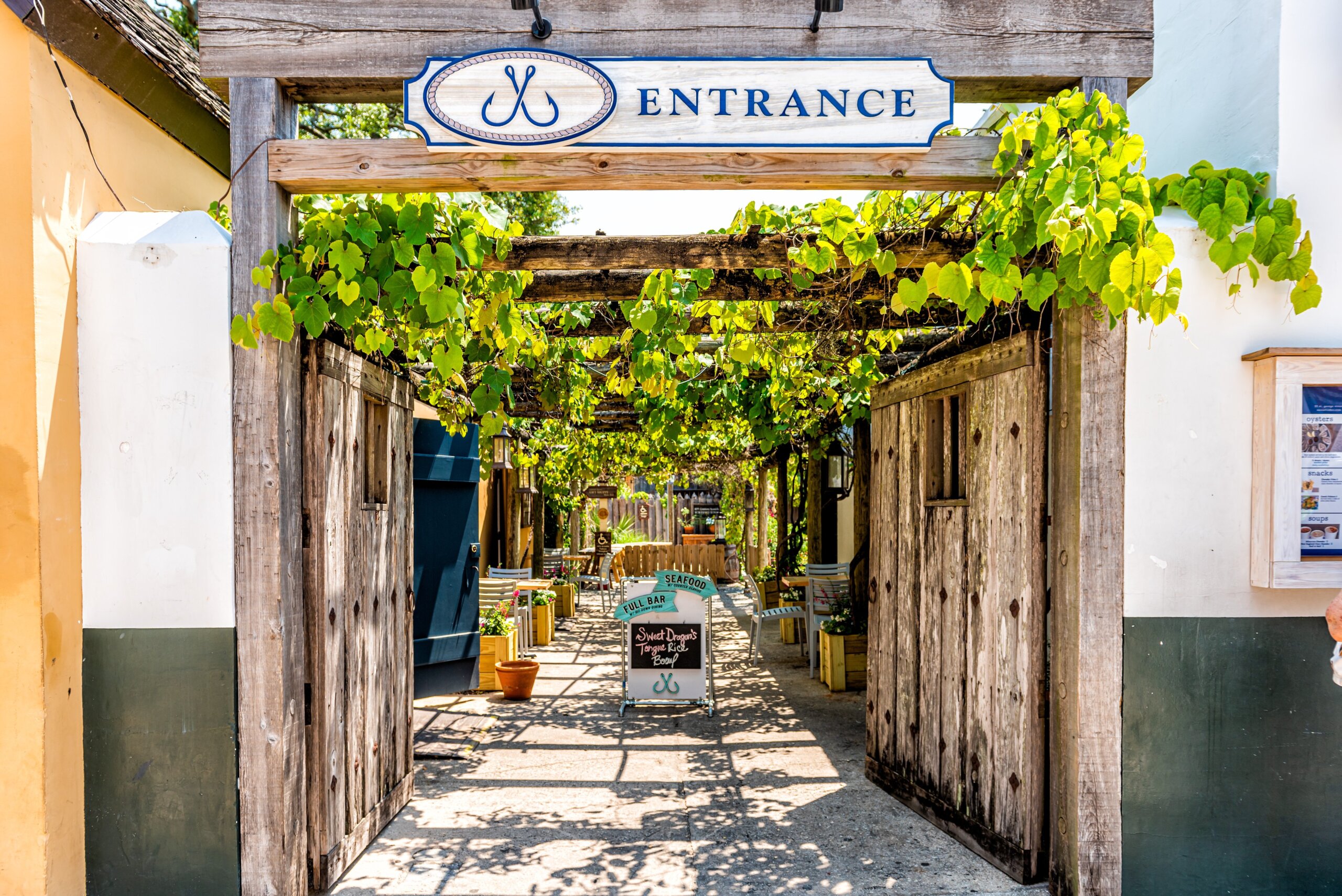 St. Augustine, USA - May 10, 2018: Shops stores restaurants alley in downtown Florida city with entrance to courtyard path architecture in famous colonial quarter historic city