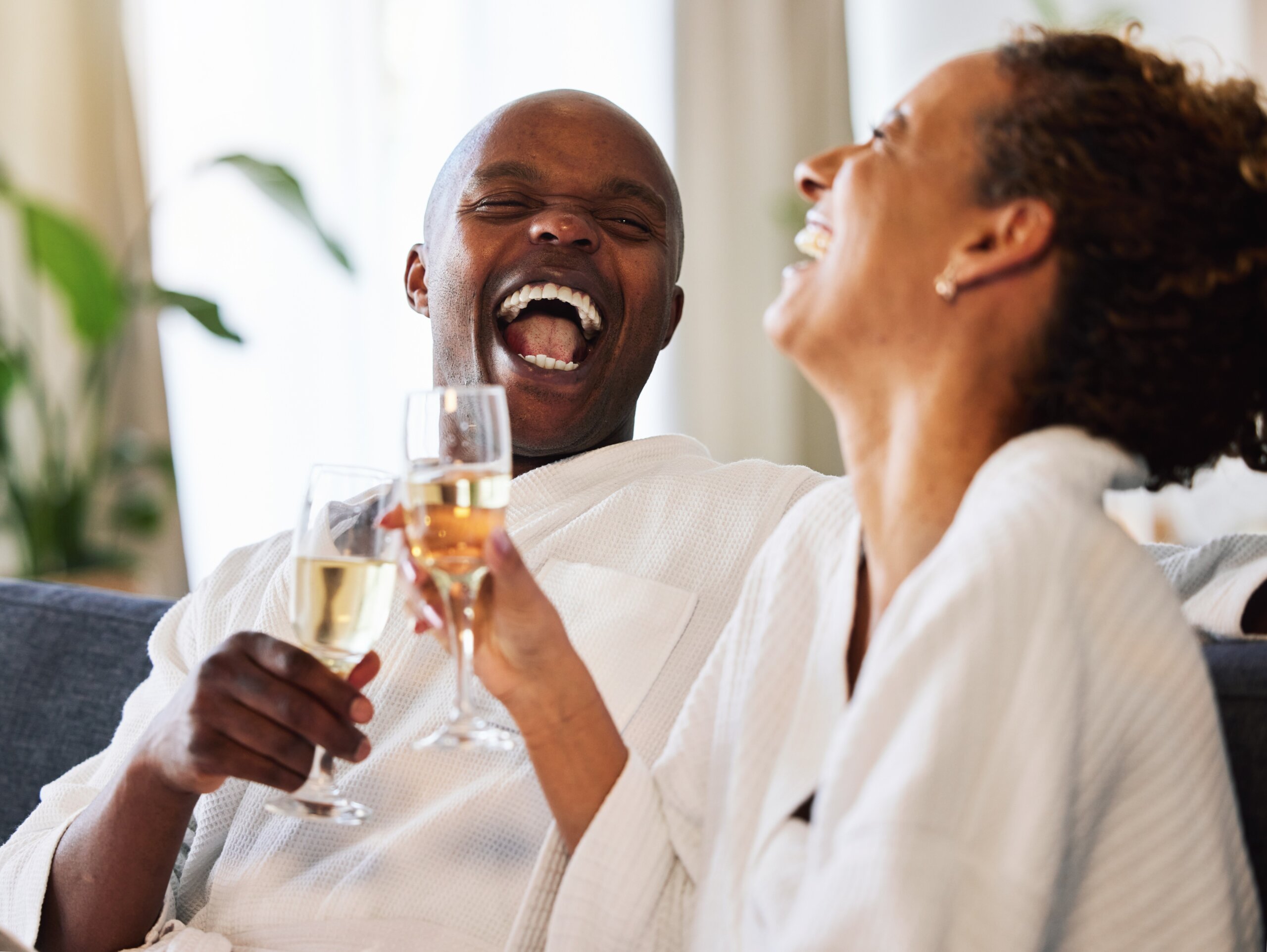 Spa, portrait and black couple champagne toast for marriage, wellness and love together with joyful smile. Happy, celebrate and health of married people enjoying luxury anniversary staycation.