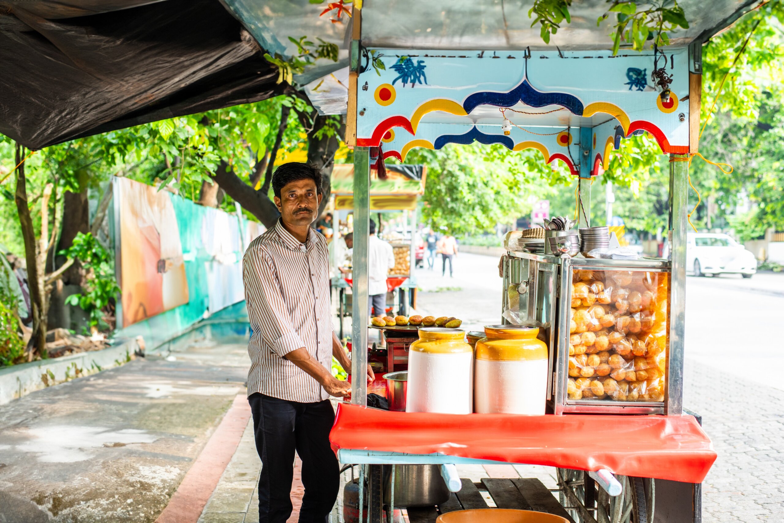 panipuri shop -happy young male Indian roadside vendor selling golgappe
