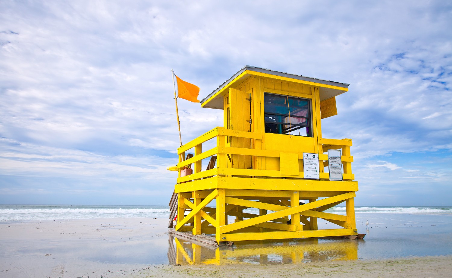 Yellow lifeguard tower on Siesta Key Beach, Florida, during October, illustrating seasonal beach conditions and red tide issues.