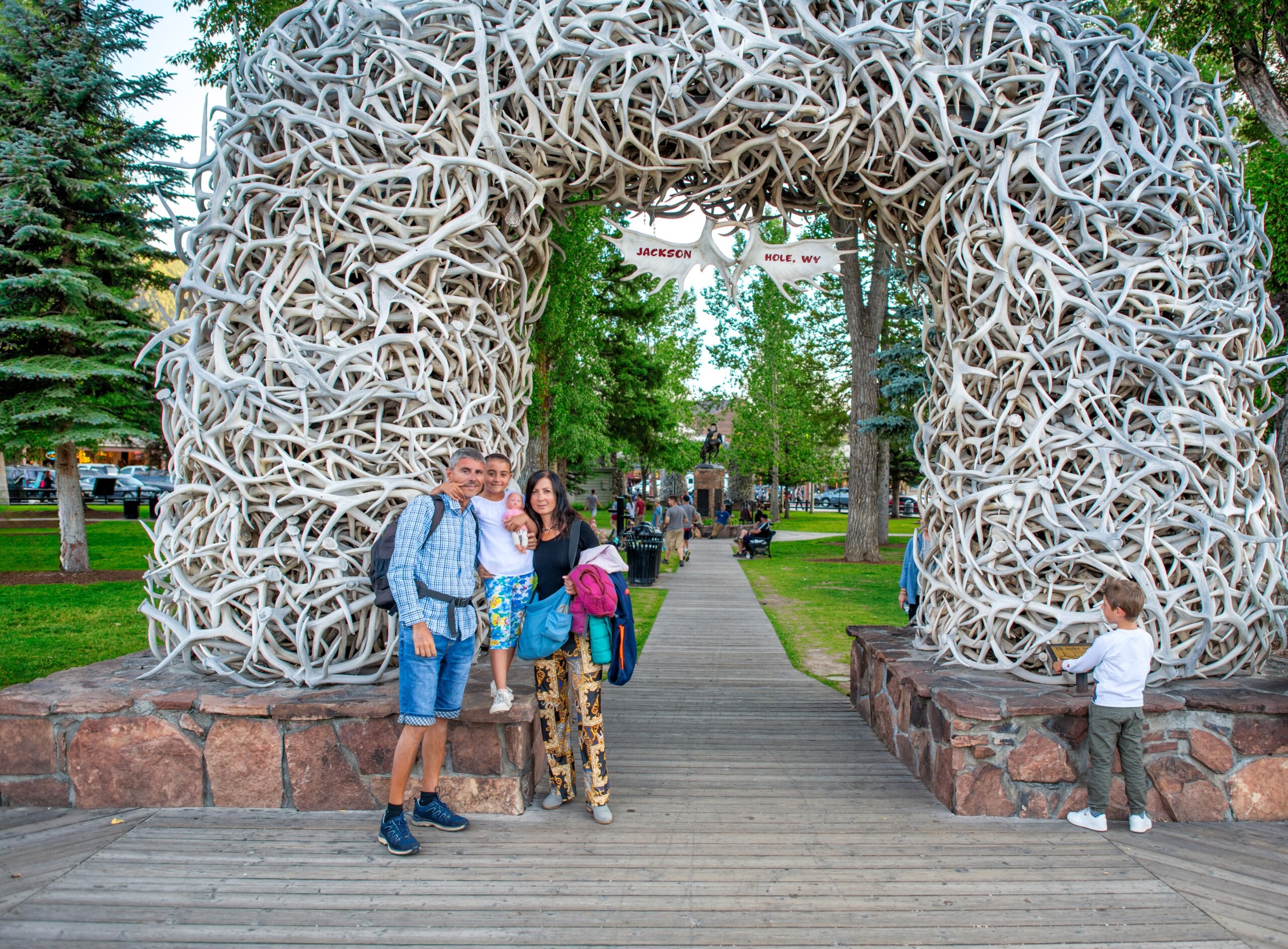 A happy family visiting Elk Antler Arches in Jackson Town Square, Wyoming