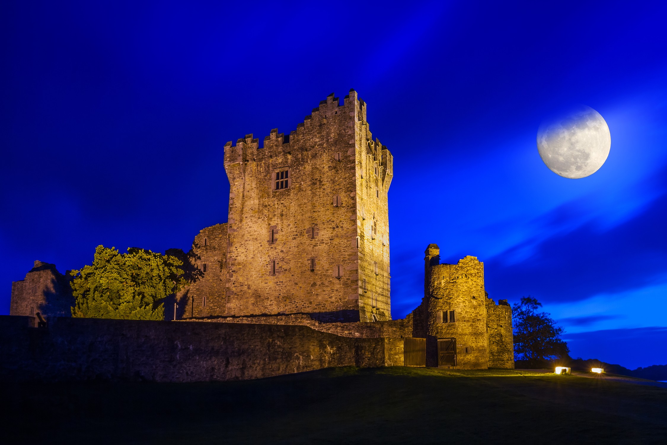 Ancient Ross castle at night with full moon, Ireland
