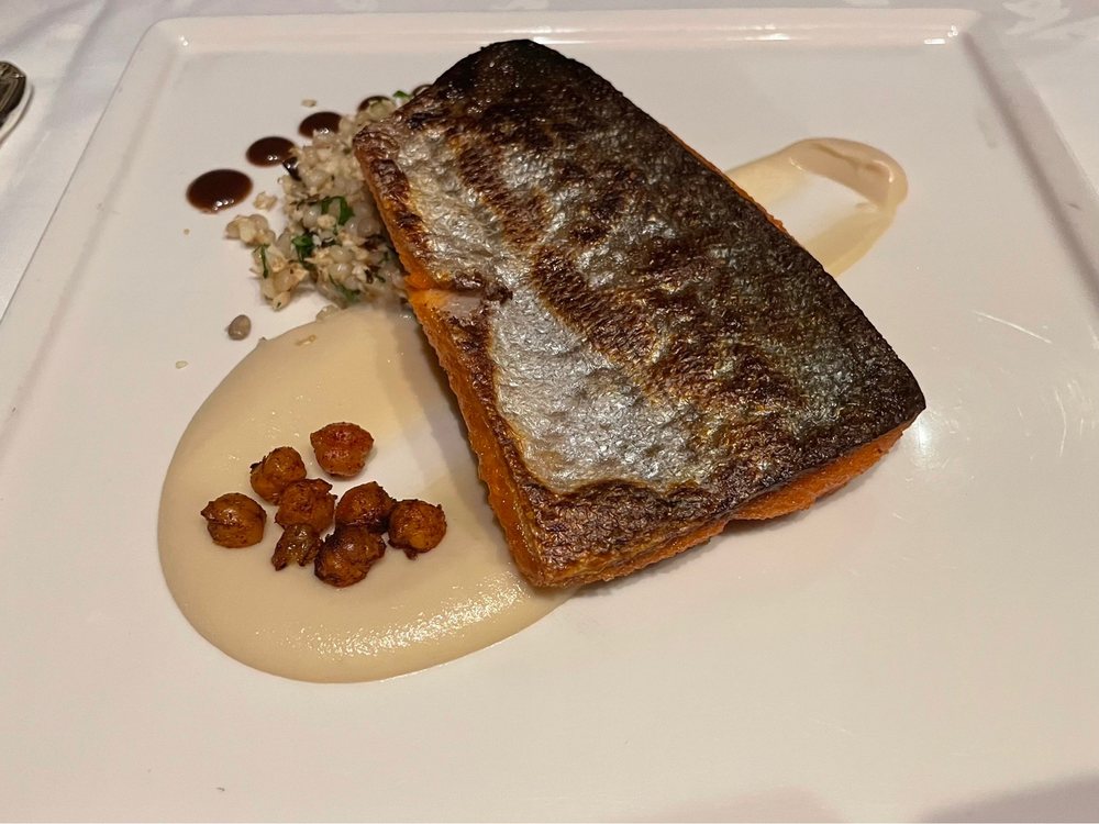 Seared black cod with creamy puree at Crow’s Nest in Anchorage, a fine dining destination in the U.S. with stunning mountain views.