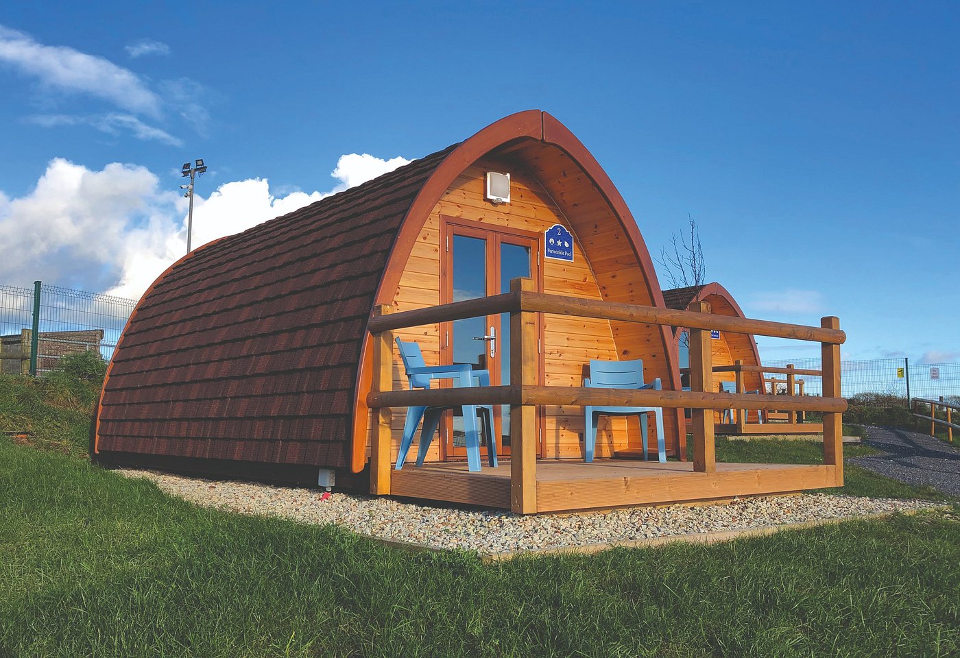 Cozy wooden glamping pod with a small deck and ocean views at Ardmore Glamping Pods in County Waterford, Ireland.