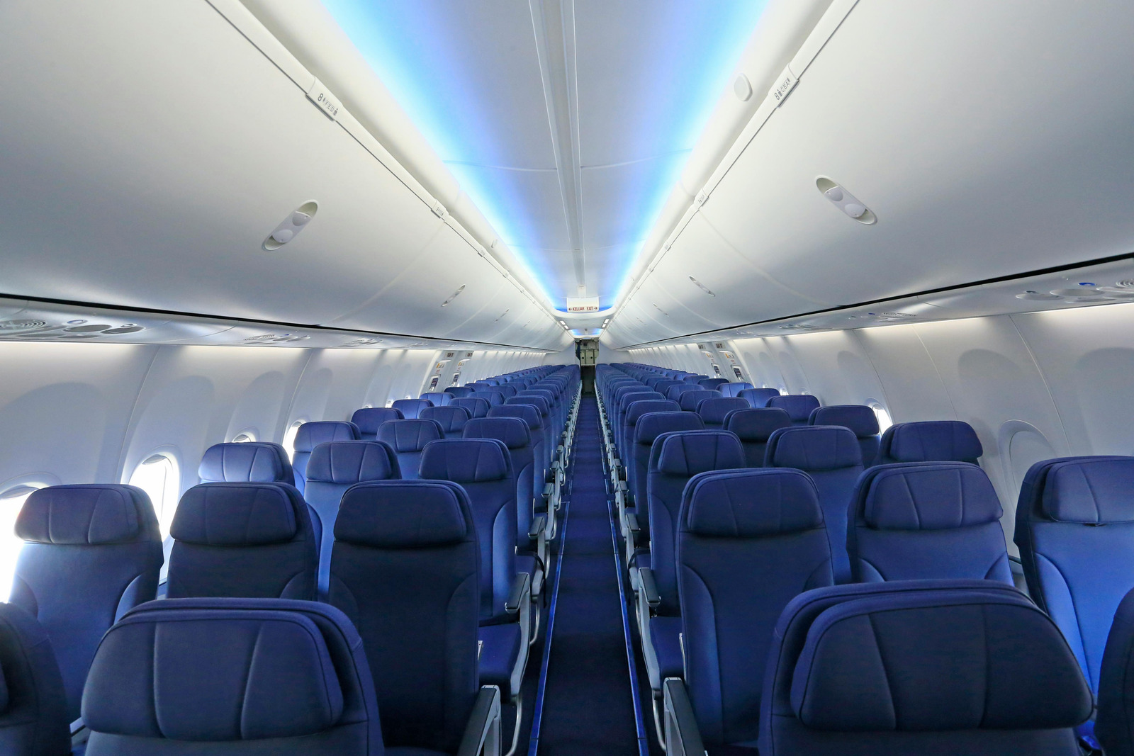 Empty airplane cabin with blue seats showing airplane comfort tips like checking seat layouts to feel less crowded on a plane.
