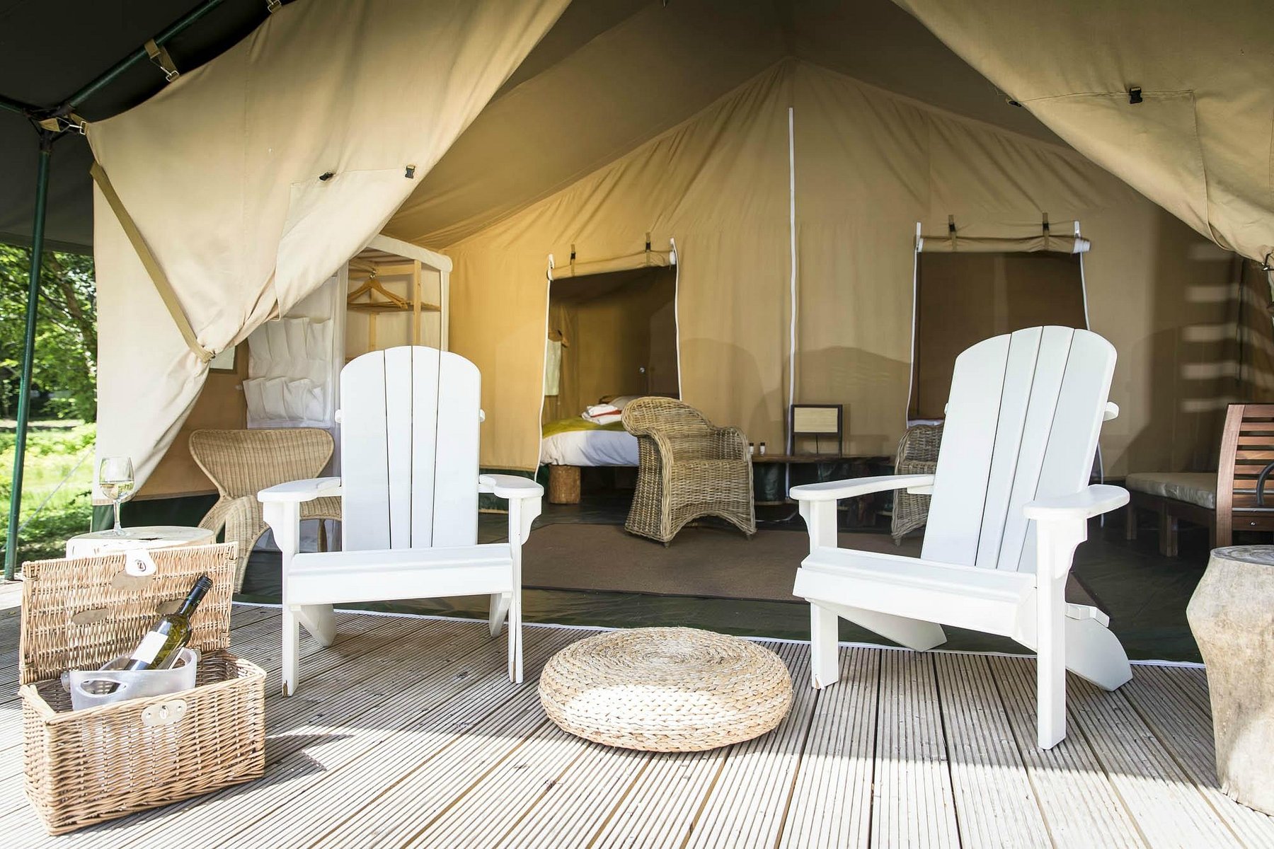 Safari-style luxury glamping tent with Adirondack chairs and a wicker picnic basket at Dromquinna Manor in Kenmare, County Kerry.