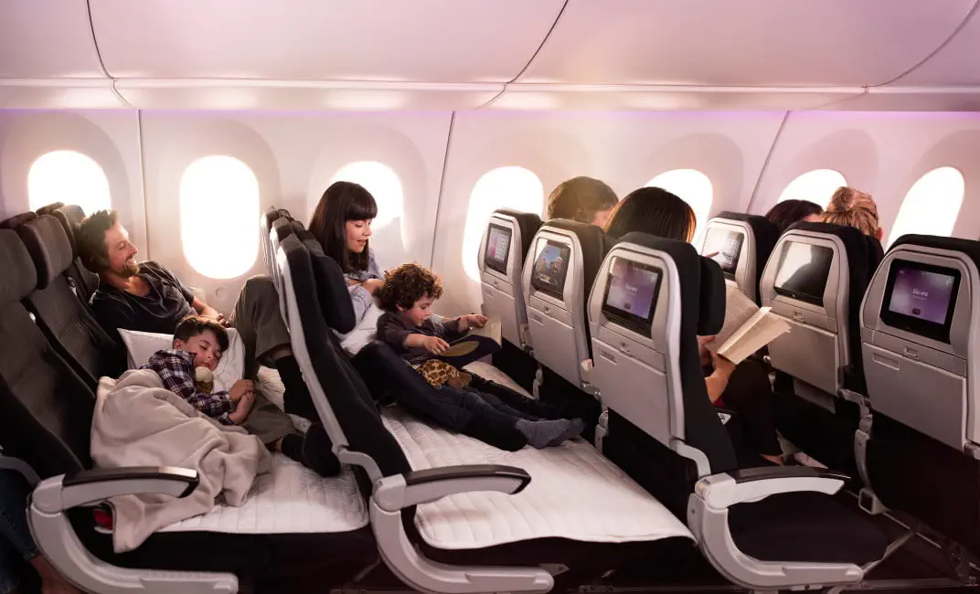 Family relaxing on Air New Zealand’s Skycouch, a comfort innovation helping passengers feel less crowded on a plane.