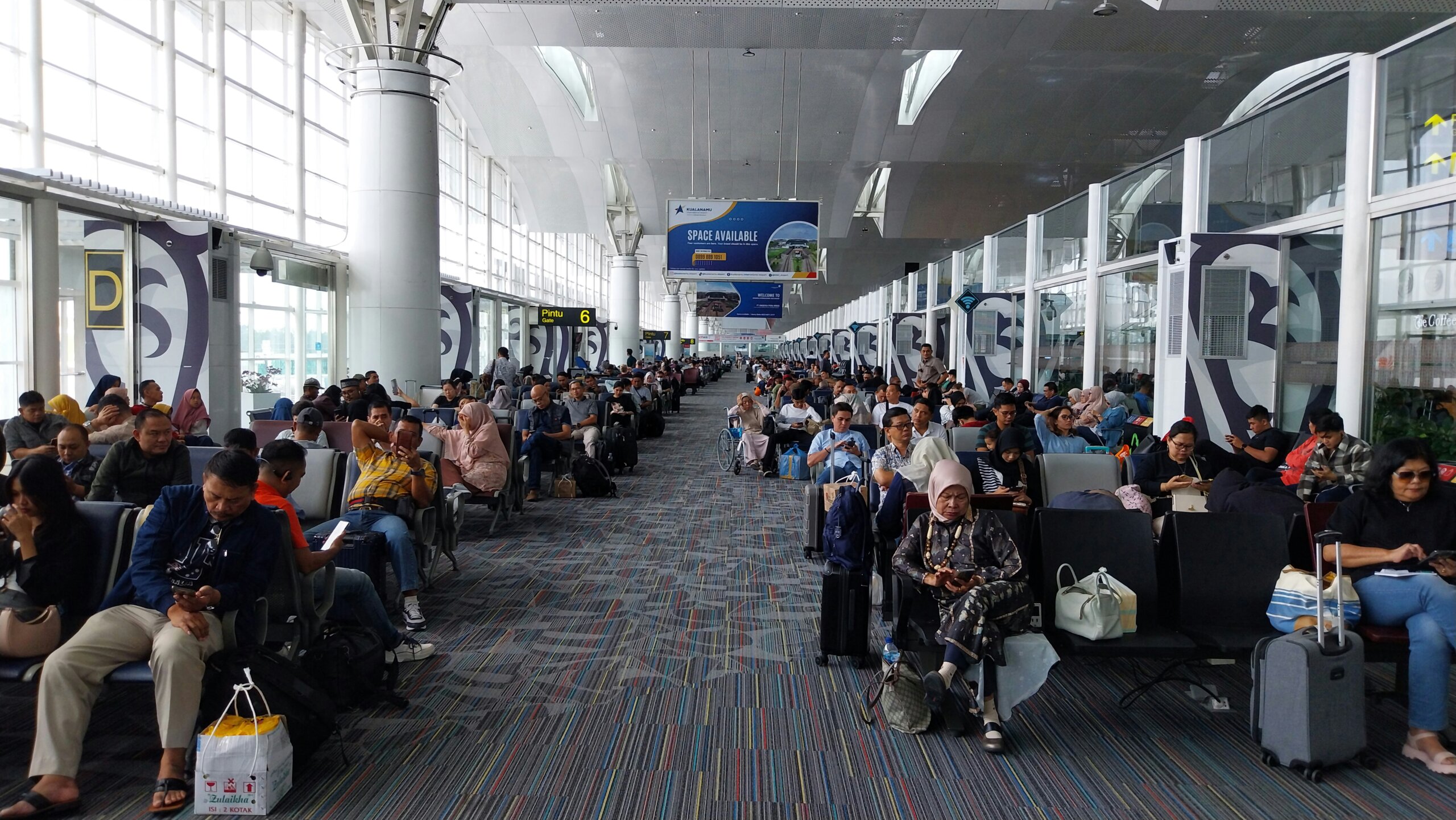 Travelers waiting in a crowded airport terminal during a flight delay