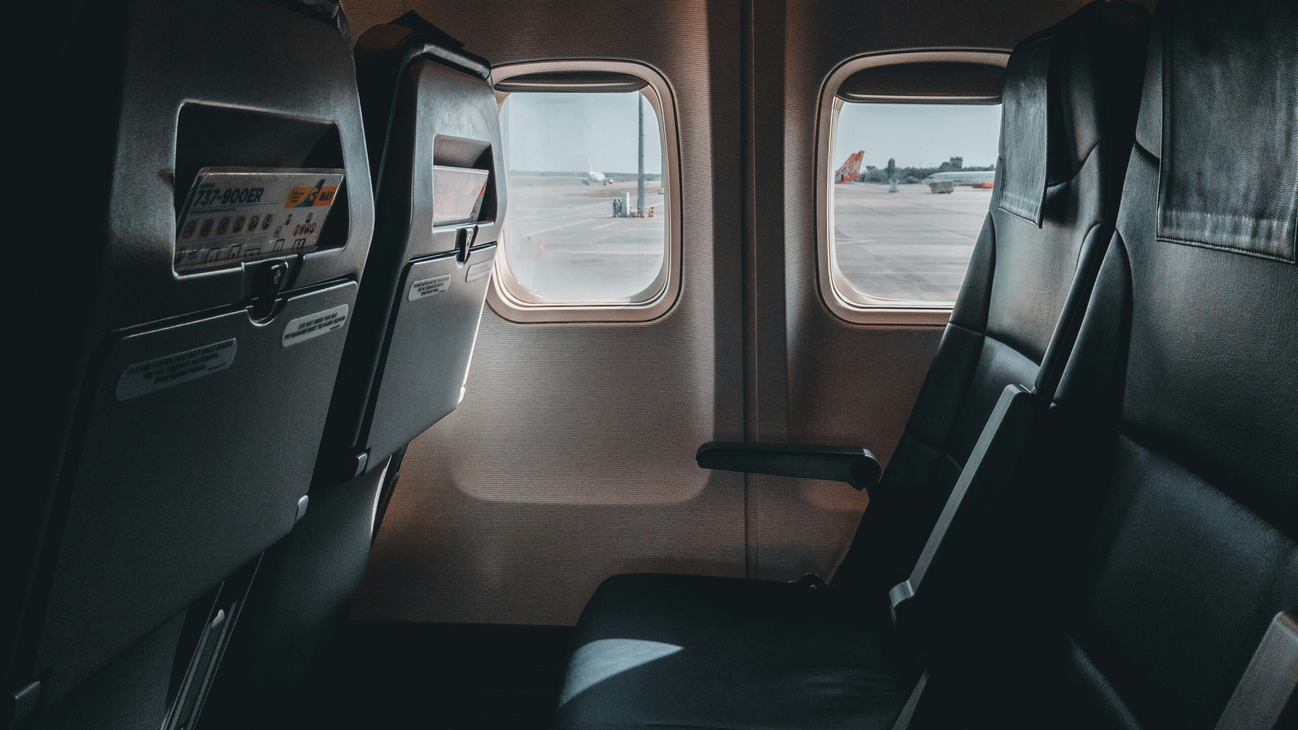 Empty airplane seats by a window showing travel comfort and space-saving flight tips