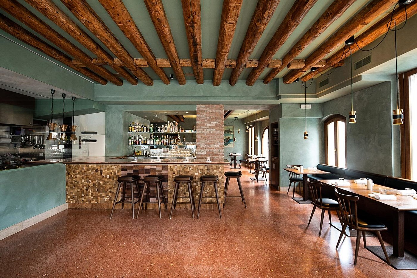 Interior of Local restaurant in Castello, Venice, featuring wooden beams, modern bar, and elegant dining space.