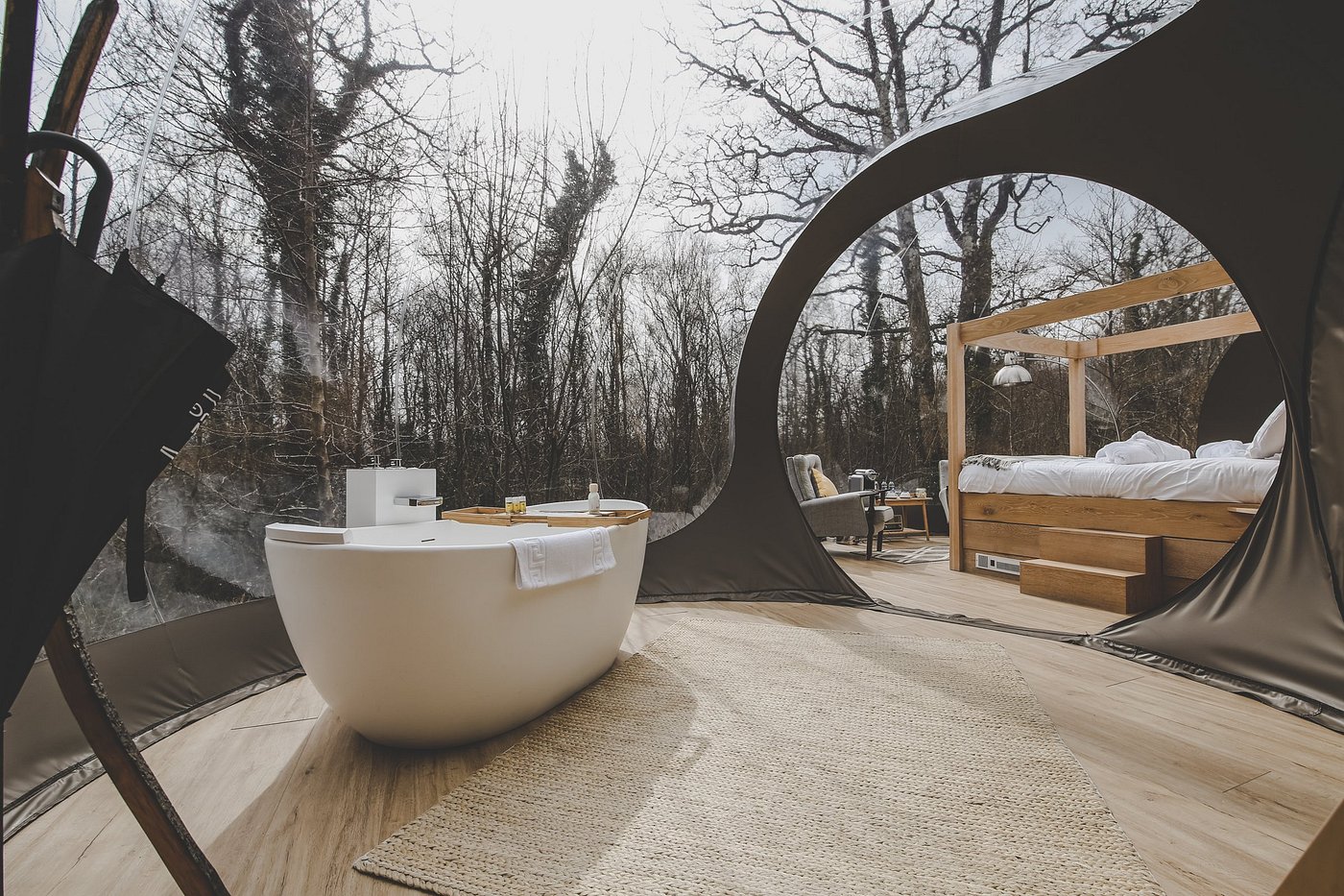 Luxury glamping dome in an Irish forest with a bathtub and canopy bed for a cozy escape