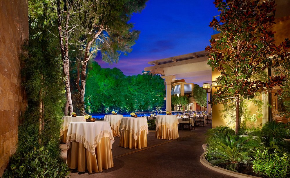 Elegant outdoor tables overlooking the Lake of Dreams at SW Steakhouse, part of the exclusive Las Vegas dining experiences at the Wynn.