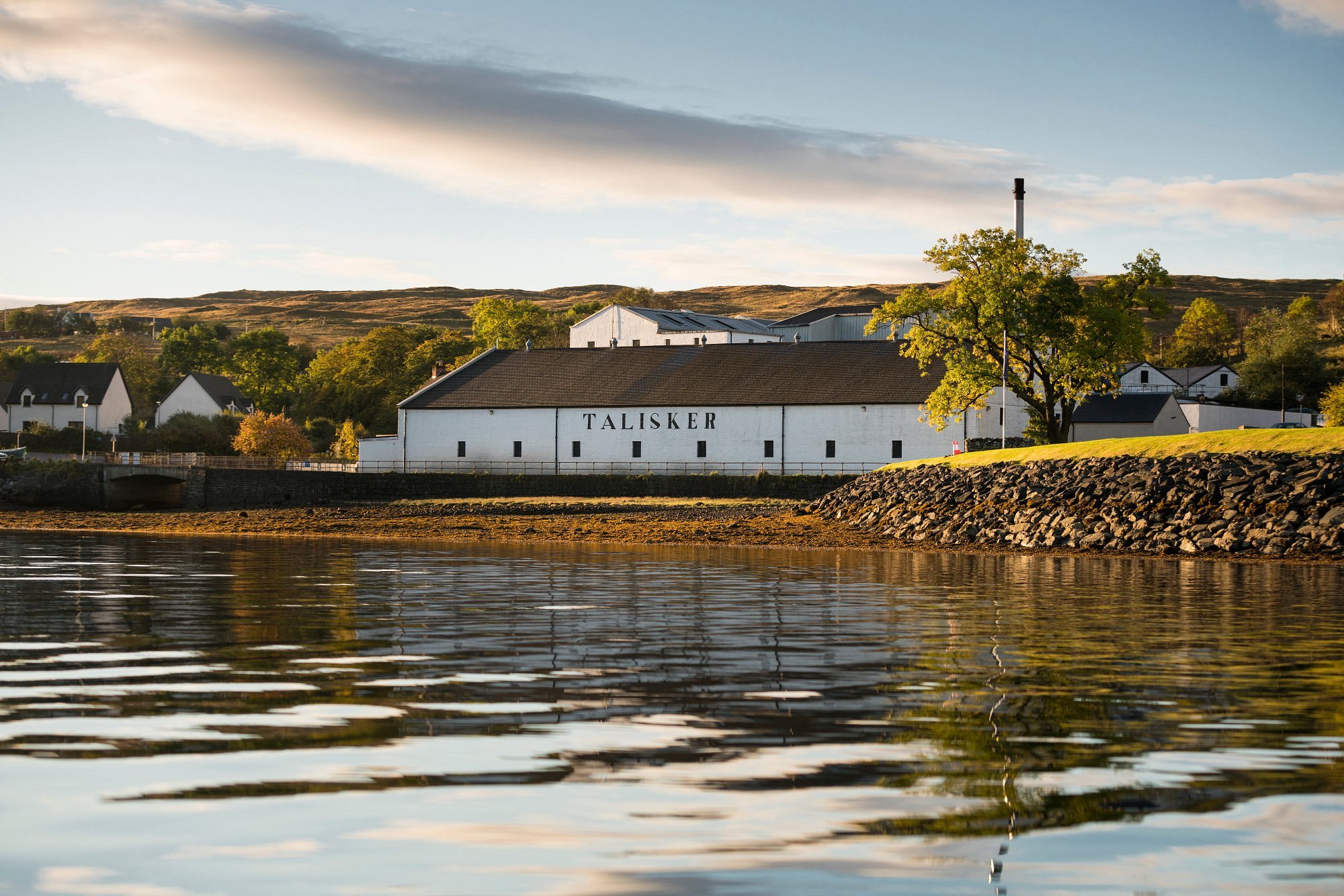 Talisker Distillery on the Isle of Skye overlooking Loch Harport at sunset