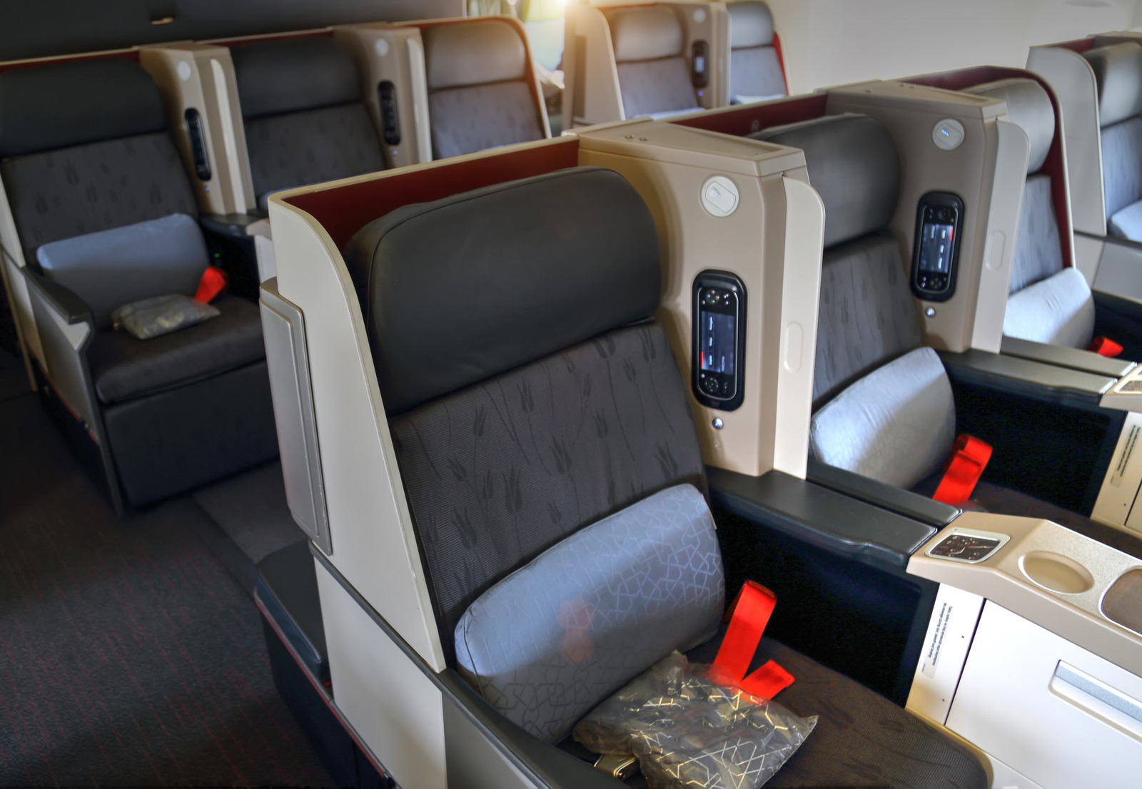 Spacious premium cabin seats illustrating airplane comfort tips like bidding for upgrades to feel less crowded on a plane.