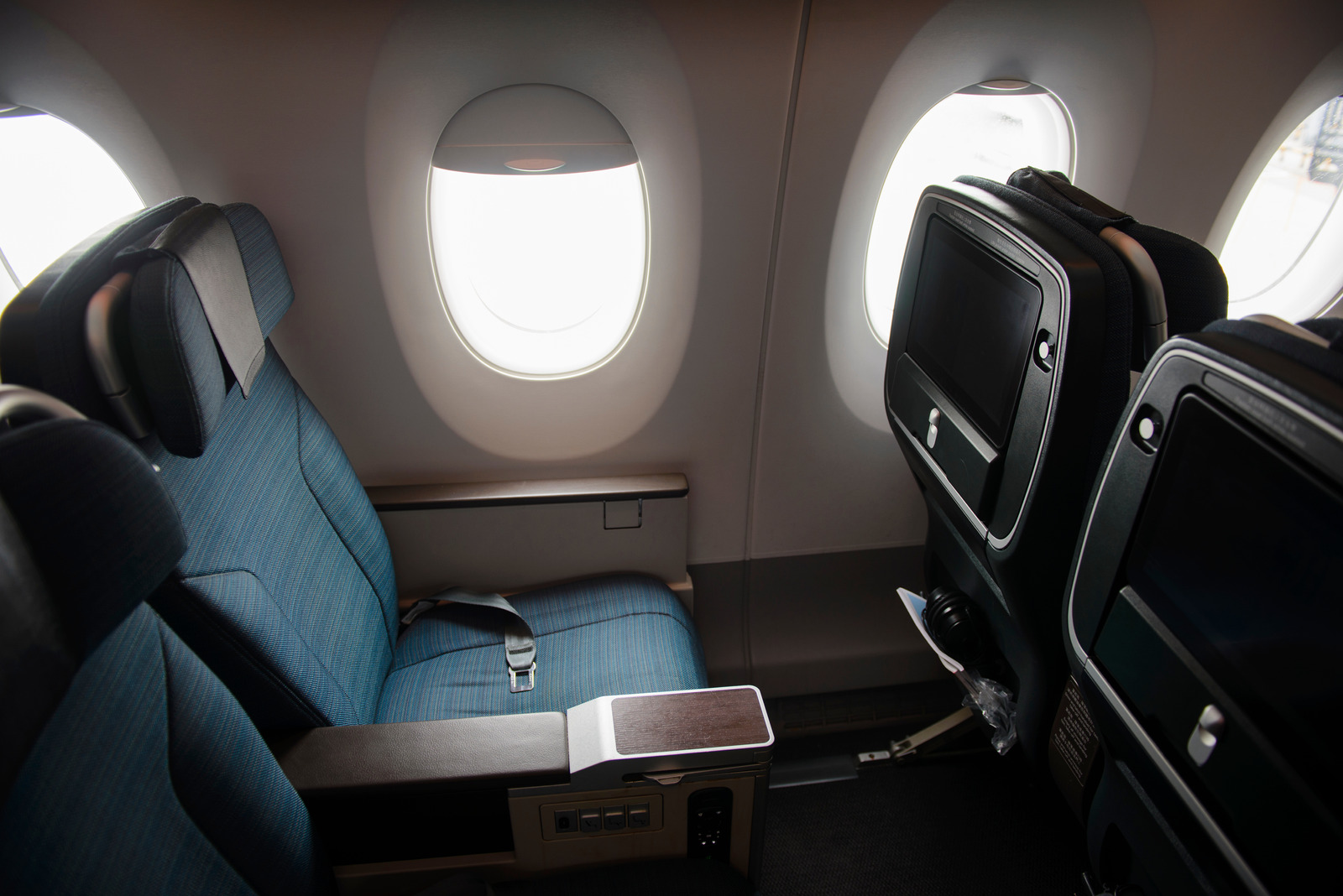 Comfortable premium economy seats offering airplane comfort tips for travelers who want to feel less crowded on a plane.