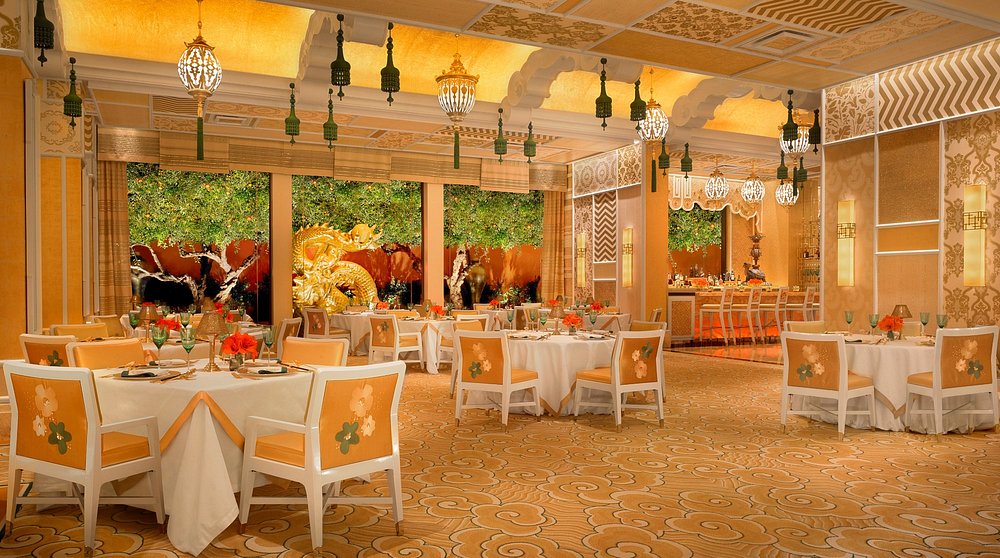 Elegant dining room of Wing Lei at Wynn Las Vegas, a Michelin-starred restaurant with gold décor and white tables.