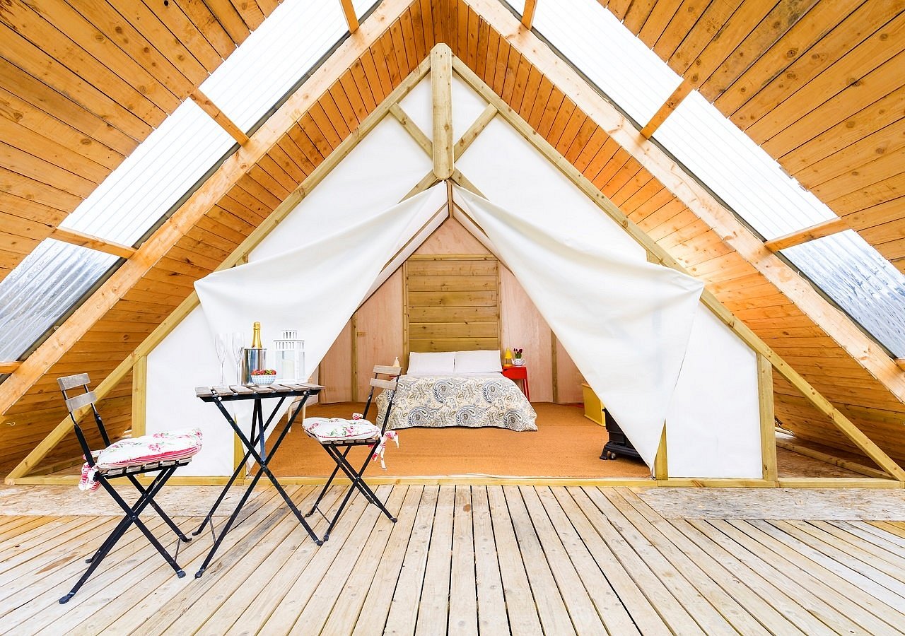 Romantic glamping pod with a private deck and bistro table inside a wooden A-frame at Killarney Glamping at the Grove, County Kerry.