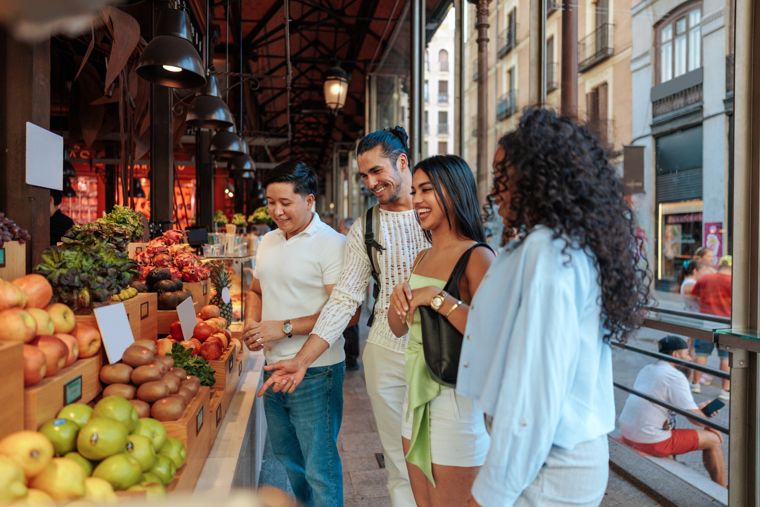 Tourists buying fresh fruit at Mercado de San Miguel in Madrid

