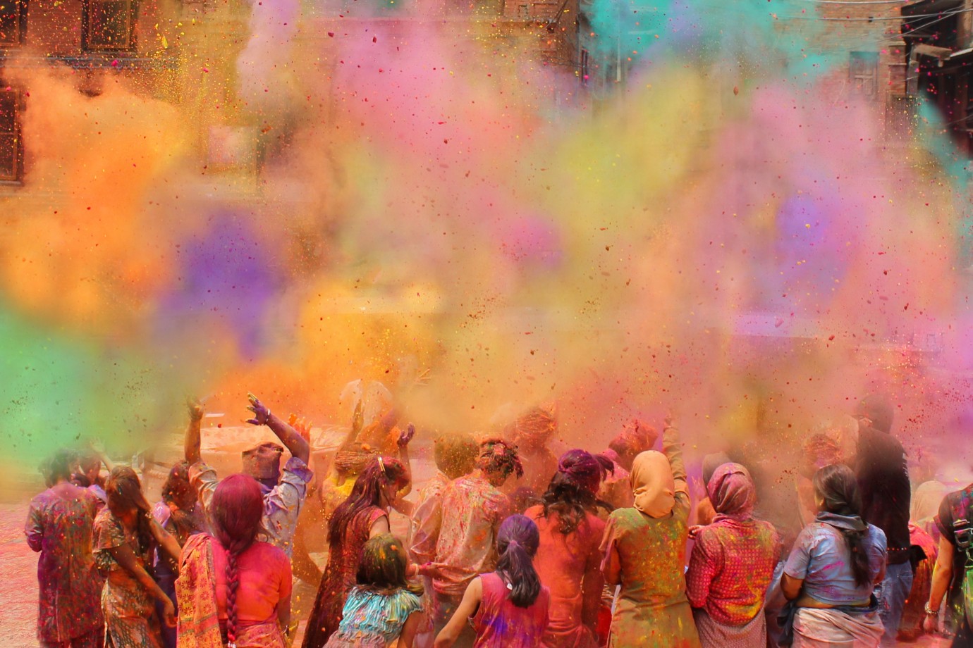 People celebrating Holi with colorful powder in India, symbolizing cultural diversity and unity