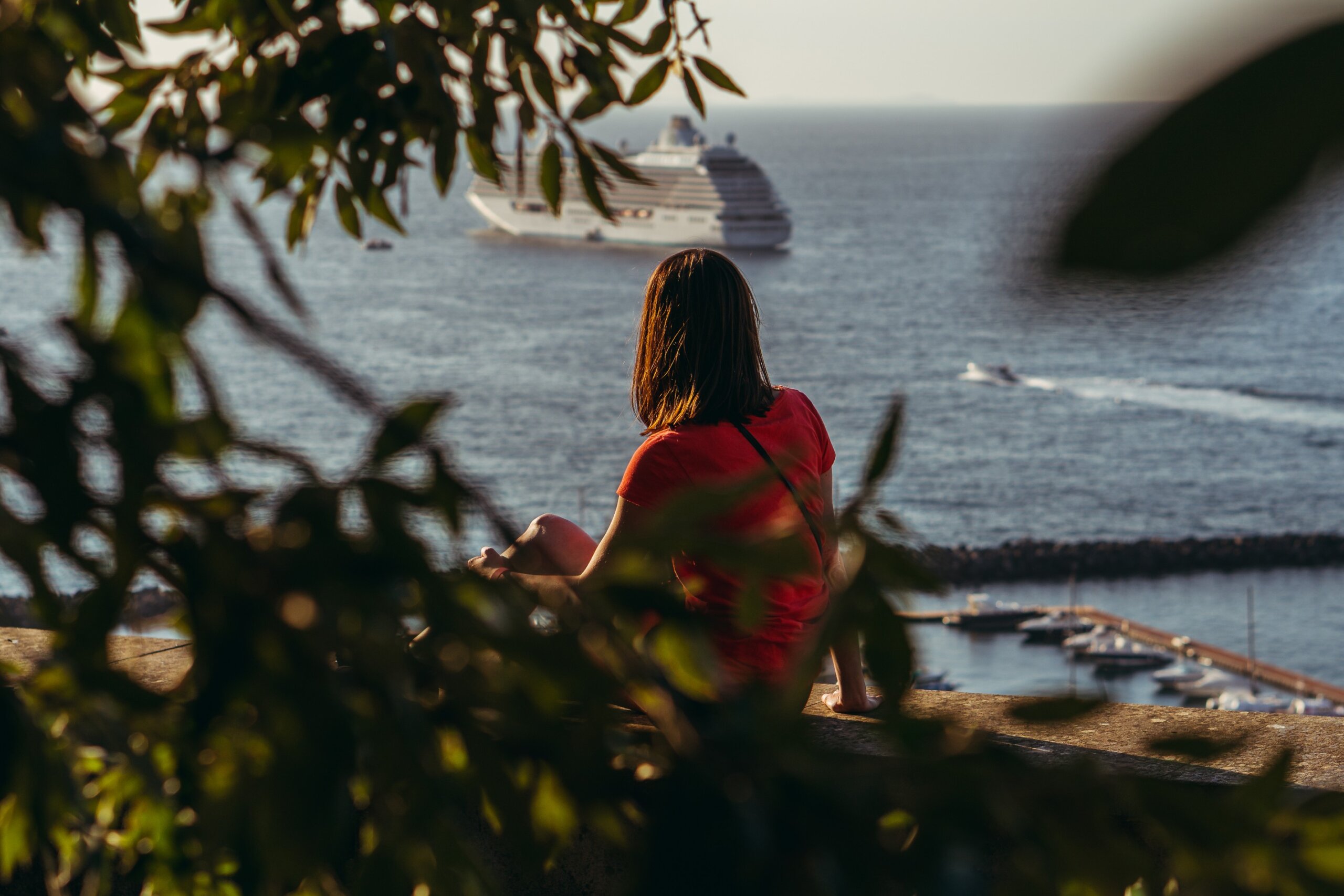 Around the world cruise. The girl looks at the ship that is sailing. Italy. Sorrento