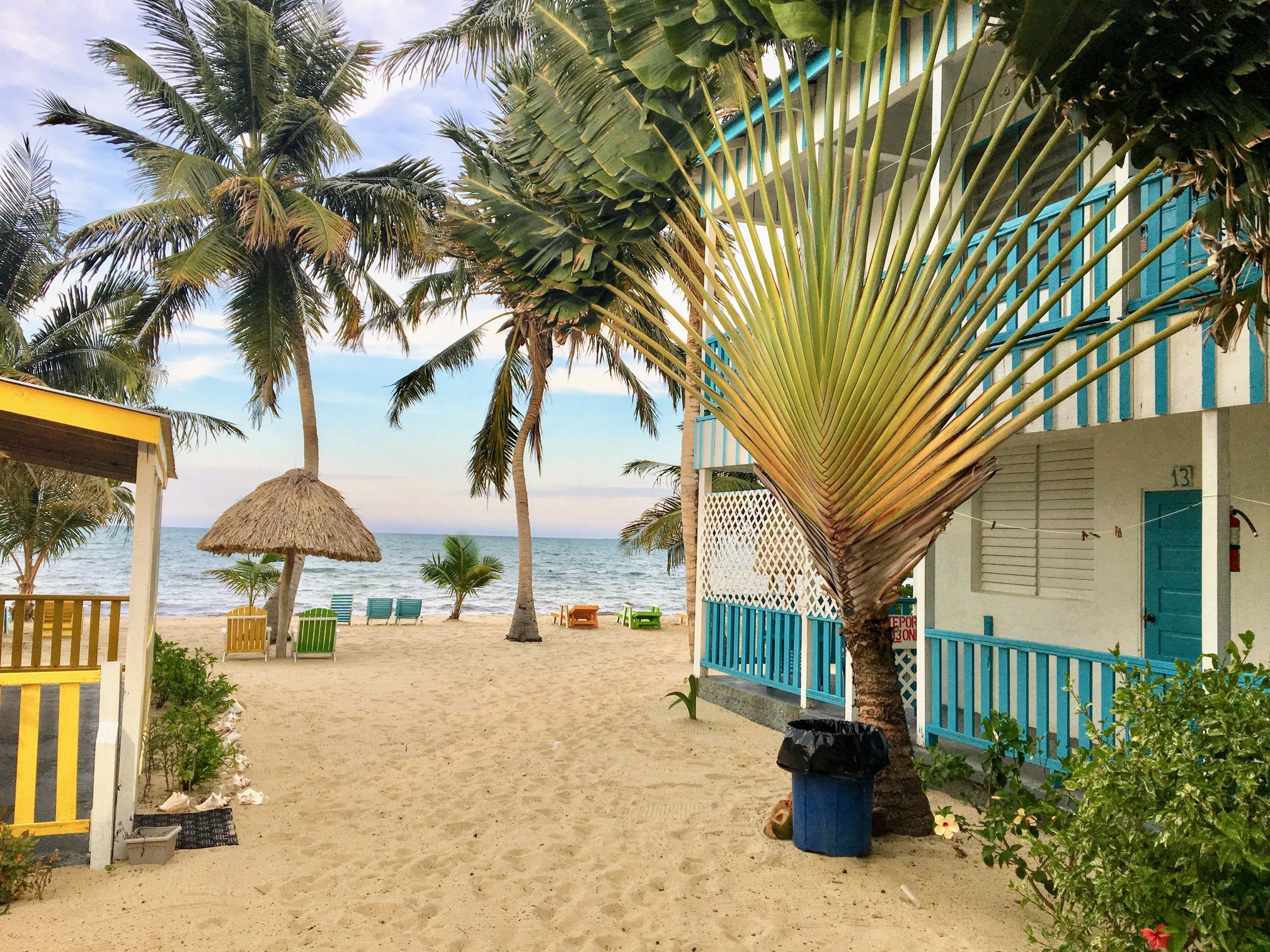 Beautiful sandy beach with a beach house surrounded by sand and flowers in the tropical town of Placencia, Belize